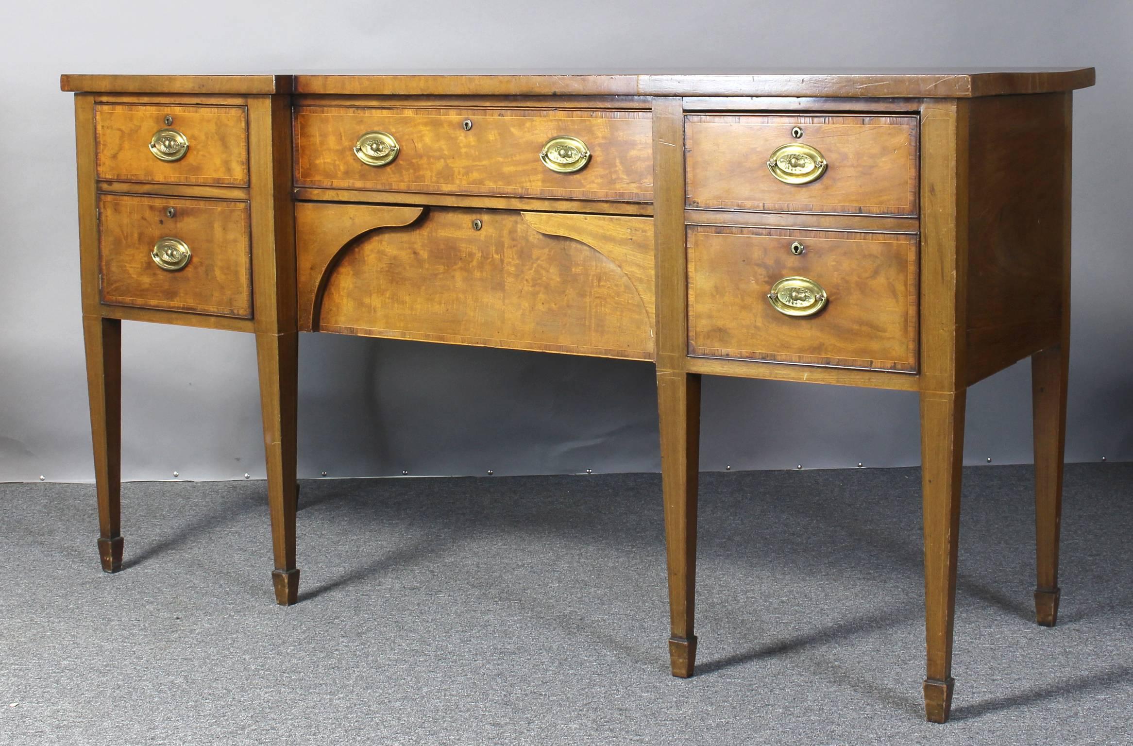 An early 19th century Scottish mahogany sideboard with ebony and rosewood cross banding, four drawers including a cellaret cabinet and an unusual false drawer hinged cabinet, supported on square tapering legs and spade feet with original thistle