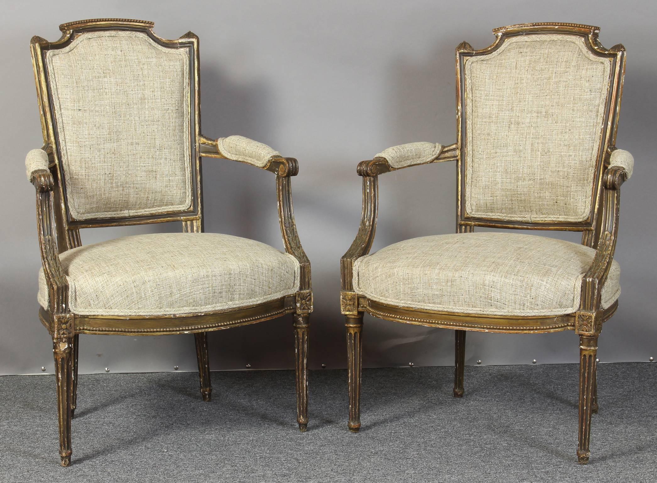 An exceptional late 18th C. French gilt and ebonized fauteuils newly upholstered in a neutral color Italian linen fabric.