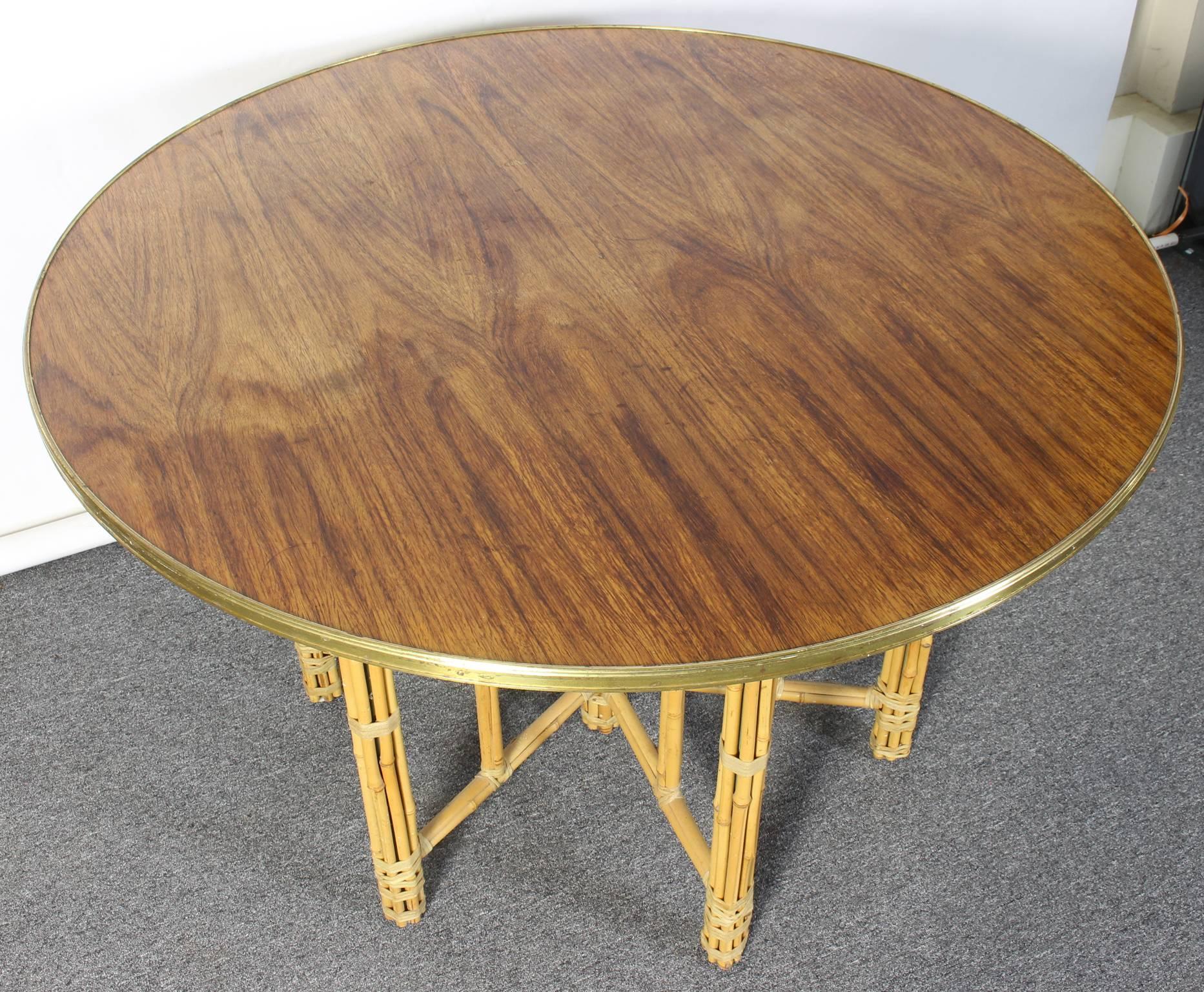 A mid-20th C. McGuire style round dining/center table with brass bound rosewood top and steel reinforced bundled bamboo base.  