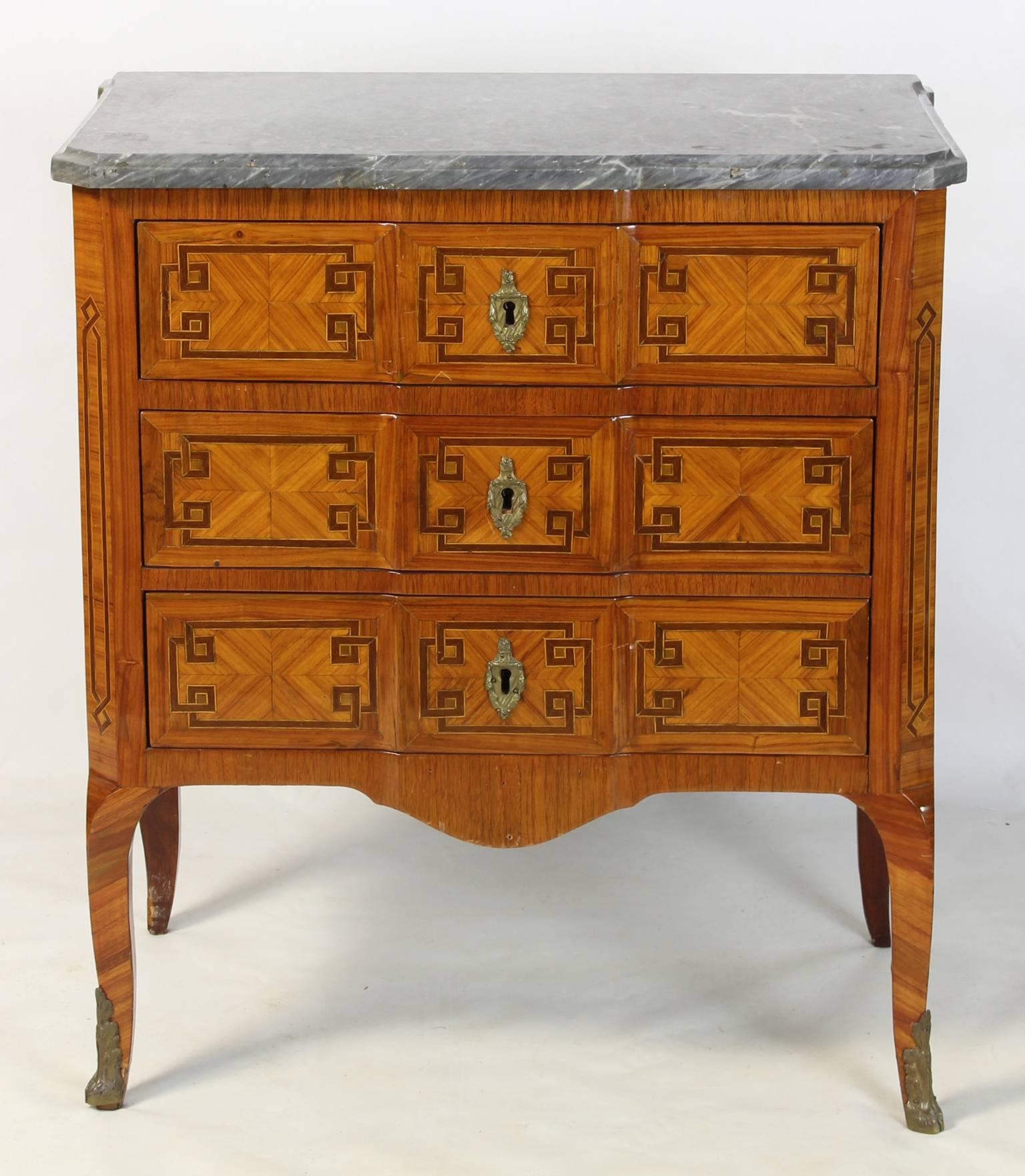 A small and elegant mid 19th C. Louis XVI style satinwood and tulipwood parquetry three drawer commode with gilt bronze fittings and original gray marble top.  