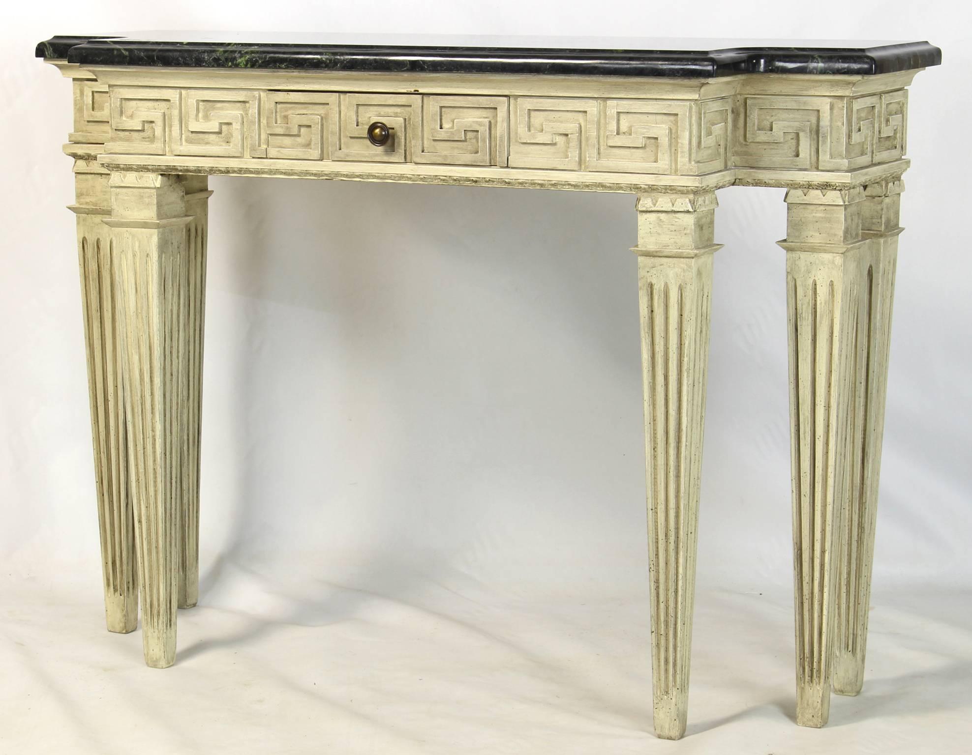 A custom designed six leg console table with Greek key decoration in a creamy gray paint finish and deep green marble top with single felt lined center drawer. 