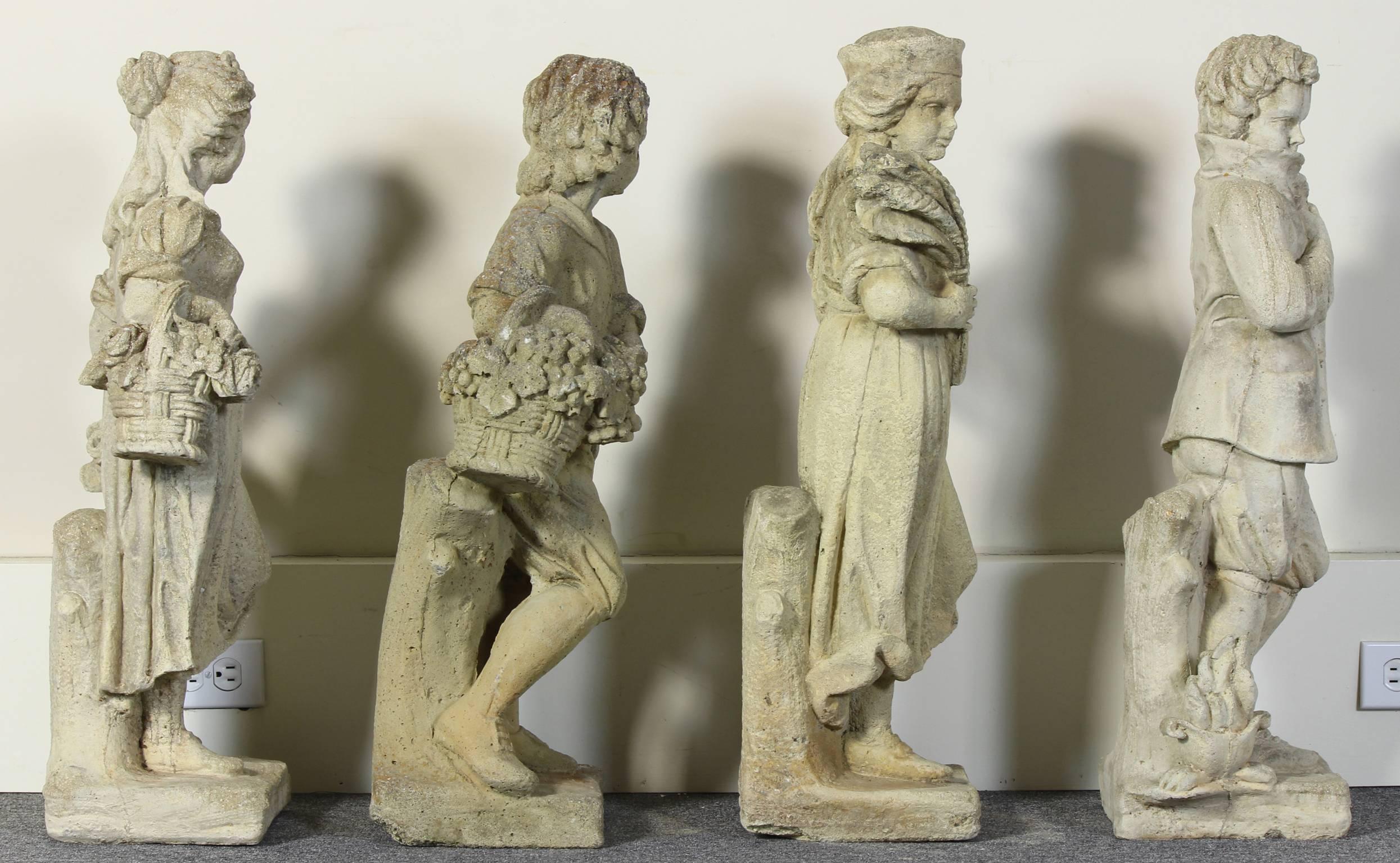 A rare set of four large cast stone garden statues depicting the four seasons comprising two male and two female subjects each dressed in 18th century country attire displaying symbols off their respective season.