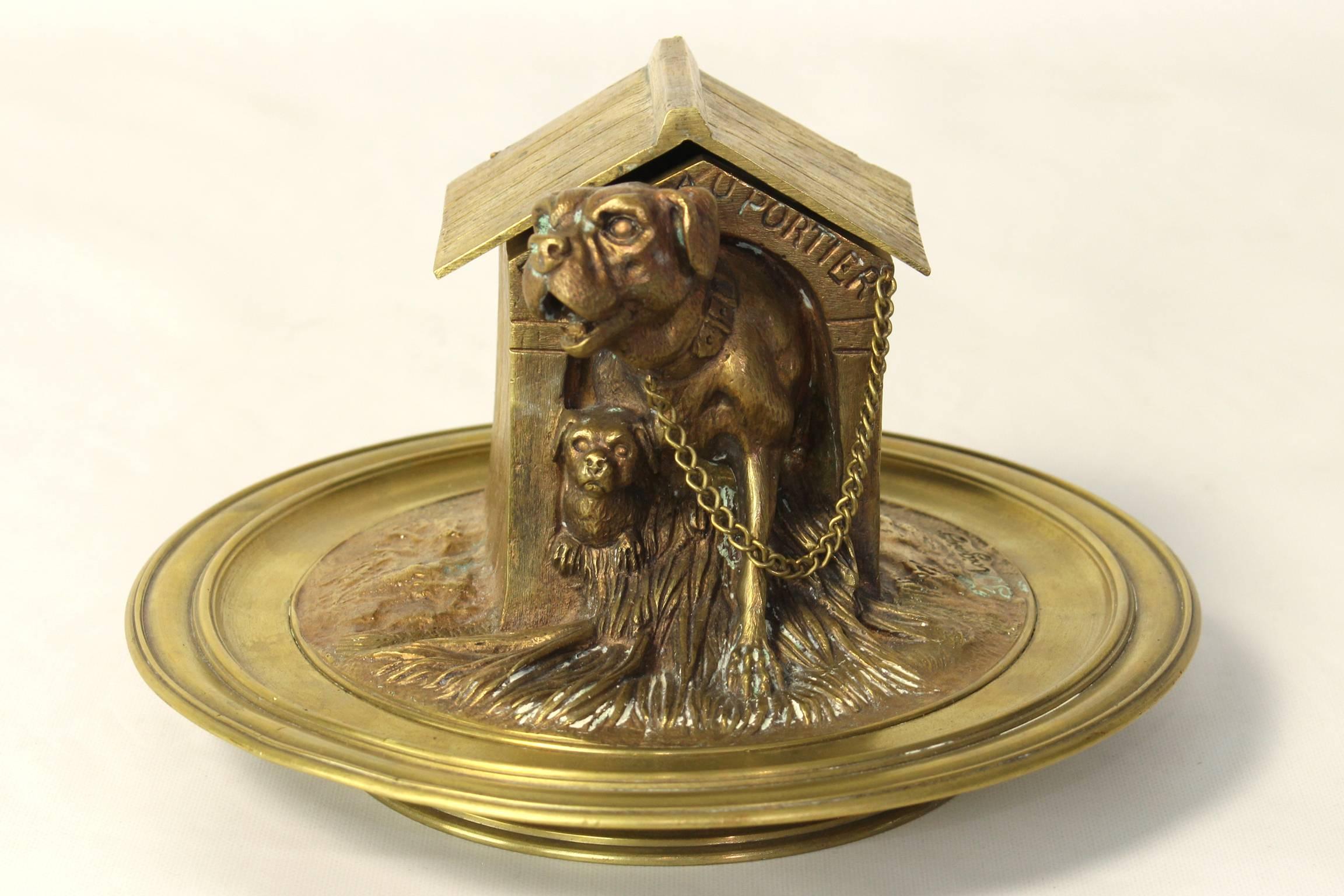 A very charming late 19th century French gilt bronze inkwell in the form of a mother dog and her pup in a rustic wooden house. The roof of the dog house conceals the ceramic inkwell. Signed bottom right.