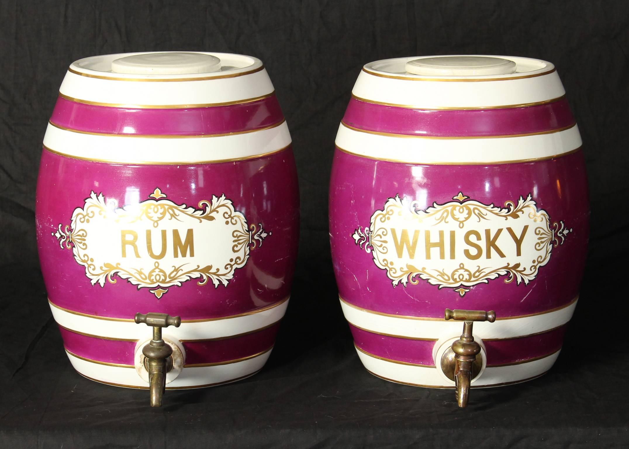 A pair of mid-19th century English spirit barrels in an unusual raspberry color with brass spigots.