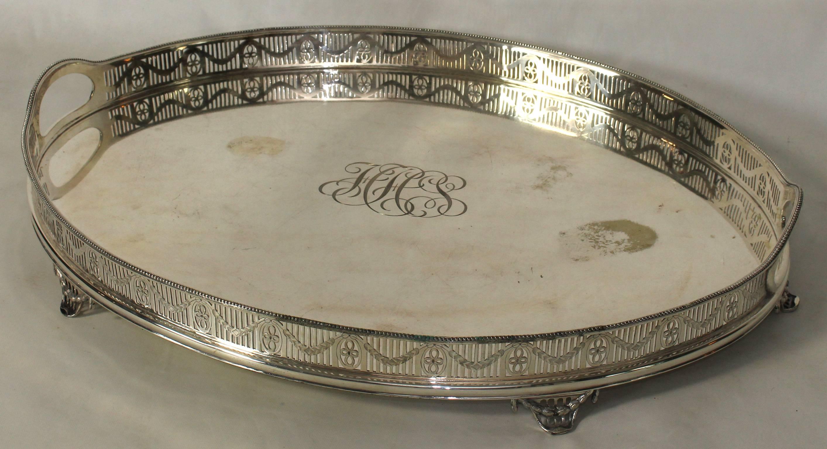 A large oval English Sheffield silver gallery tray with elaborate monogram engraved in the center.