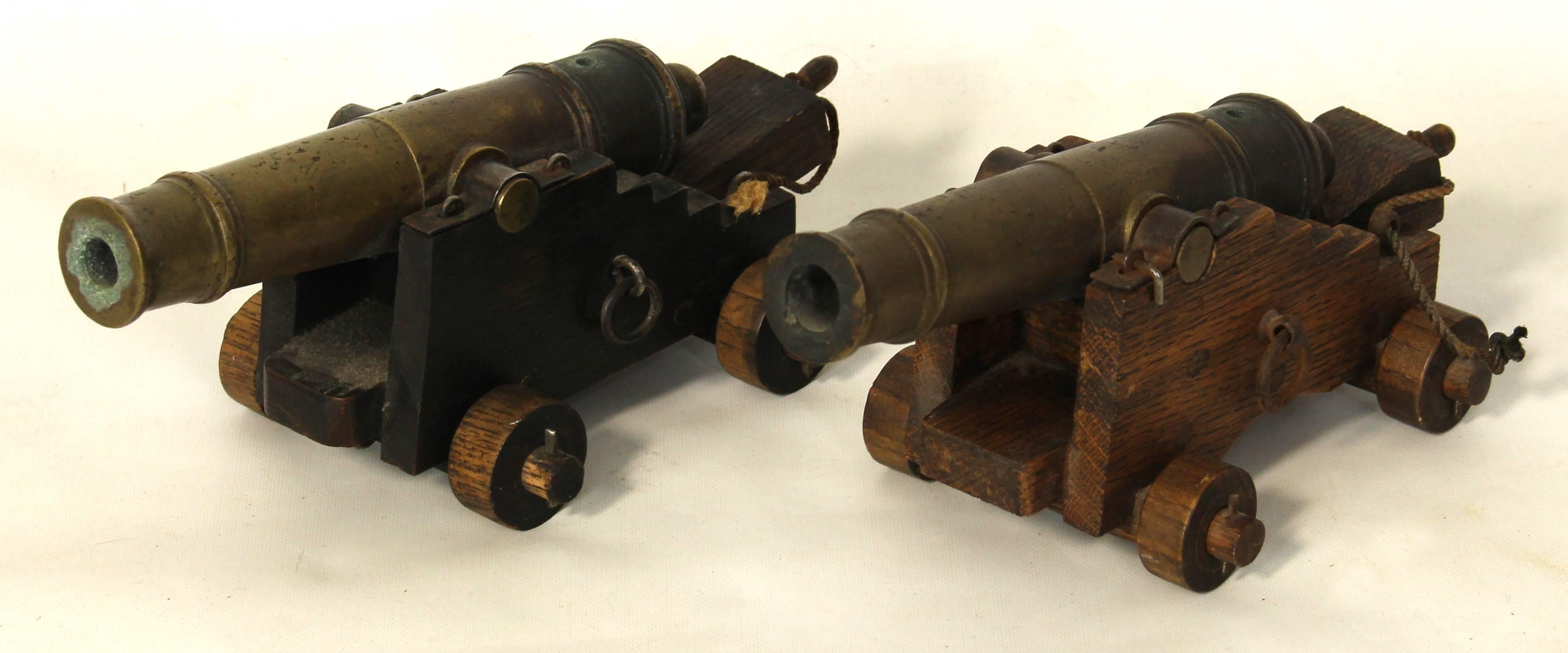 A pair of miniature 18th century style naval cannons with bronze barrels and oak carriages functioning as signal cannons.