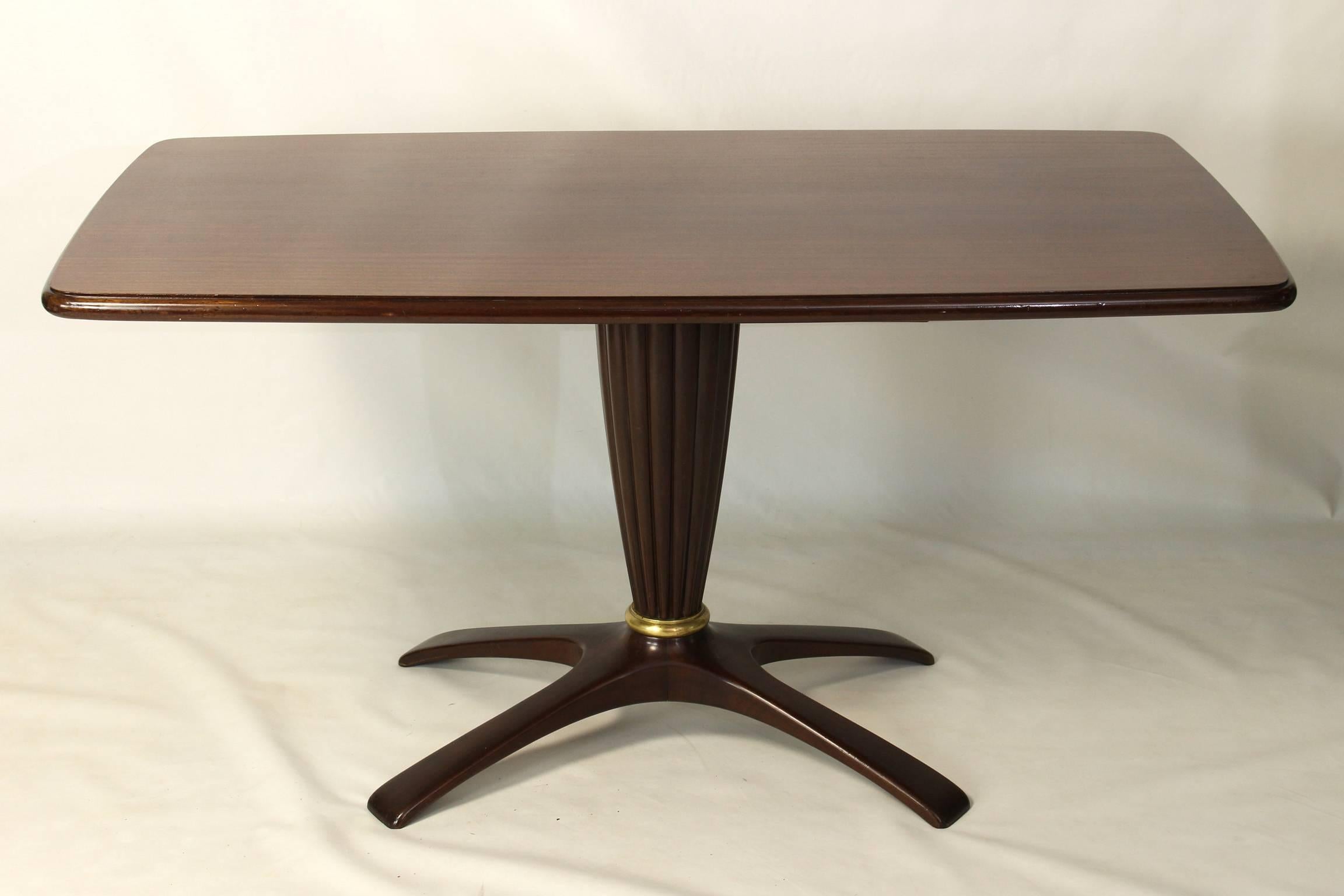 An elegant mahogany breakfast table dating from the 1940's attributed to Paolo Buffa with flared and scalloped pedestal accented with cast bronze ring and resting on arched X shaped base.