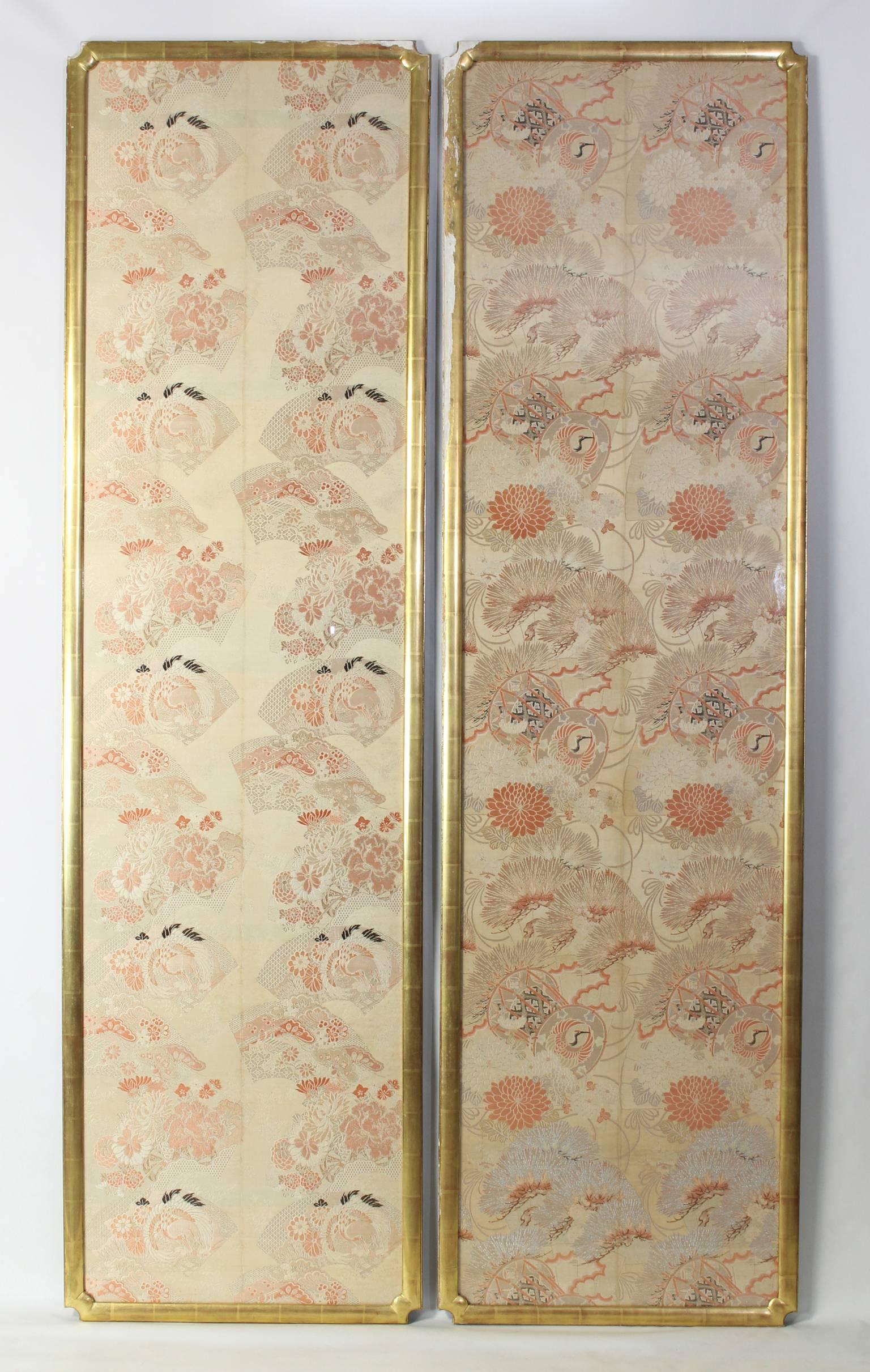 An exceptionally large and stunning pair of late 19th century Japanese silk brocade panels woven in shades of cream, pink, coral and gold with black accents mounted in 24k water gilt frames.