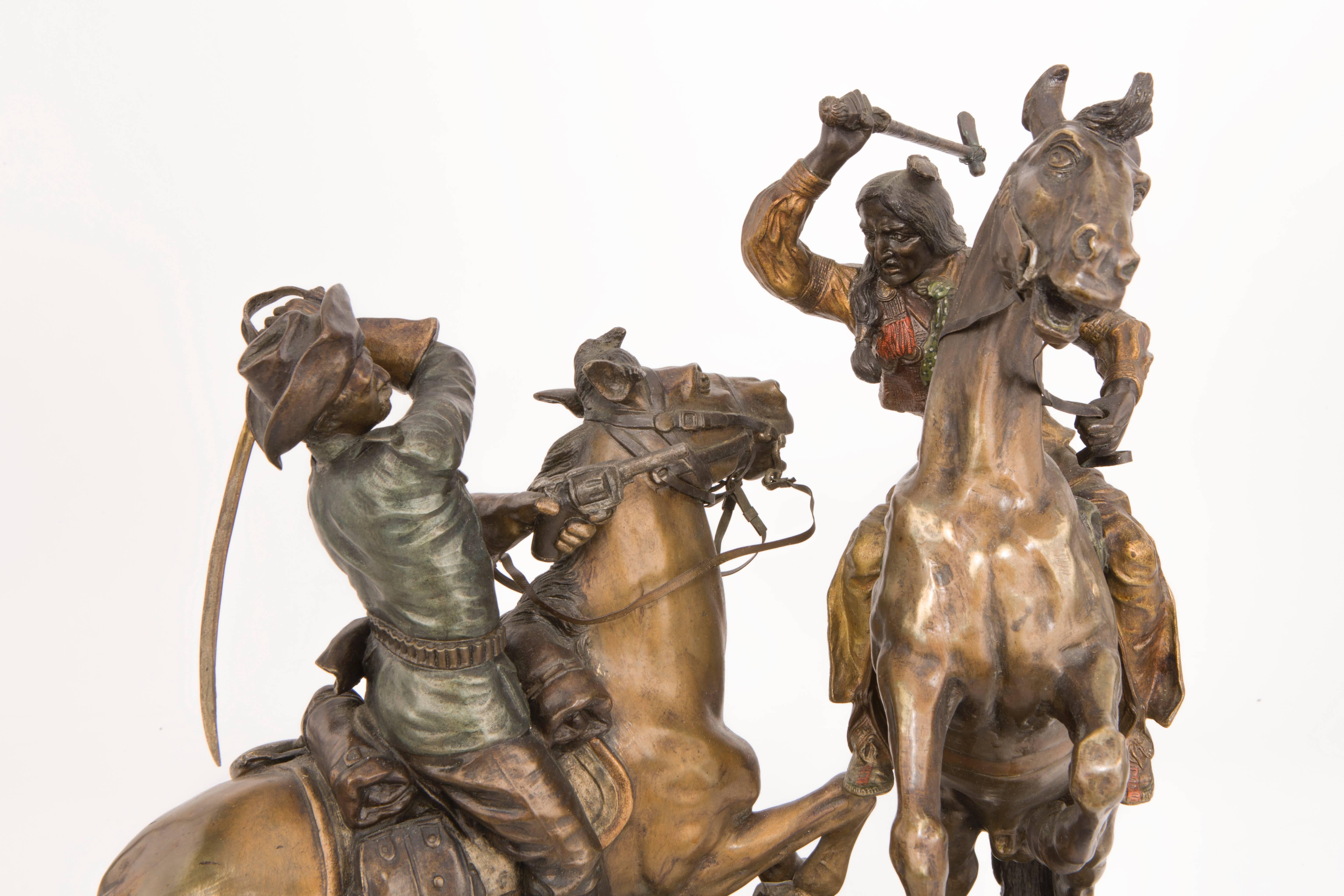 An amazing early 20th century Austrian polychromed and patinated bronze sculpture depicting there American Wild West of a Cowboy with a sword and drawn gun on Horseback attacking an Indian on Horseback with hatchet in hand by, Austrian sculptor Carl