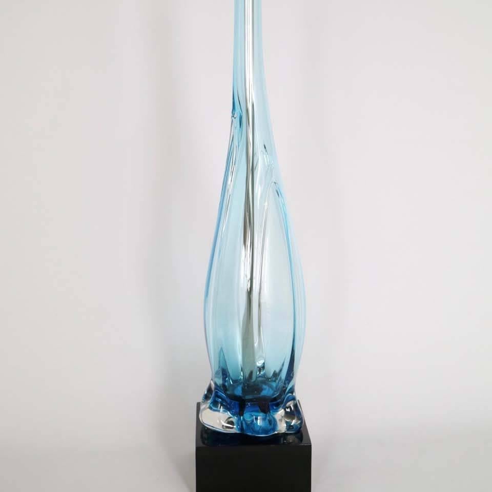 A stylish Murano glass Italian lamp by Archimede Seguso, circa 1950s, with double cluster sockets in plated nickel, over clear light blue handblown glass body, mounted on a lacquered wooden base. The lamp, fully restored with all new wiring and