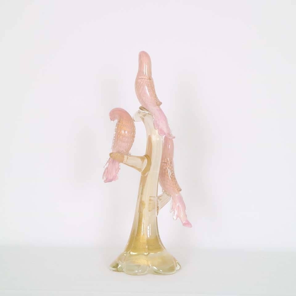 A vintage Murano glass sculpture by Venetian glass artist Alfredo Barbini, circa 1950s, depicting three soft pink birds, each decorated with 'bullicante' controlled bubbles, perched on a winding branch, with gold infusion. This piece remains in very