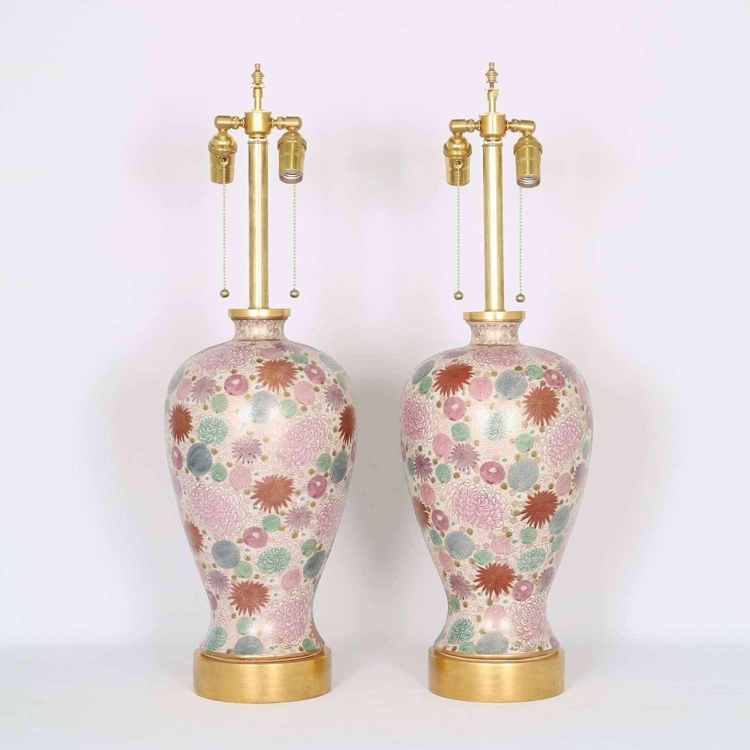 Mid-Century Modern pair of lamps with a hand painted floral motifs by Paul Hanson. The chrysanthemum motif in pink, lavender and pale blue makes this pattern unique. Mounted on wooden bases with caps in 24K gold gilding. The noted height is to the