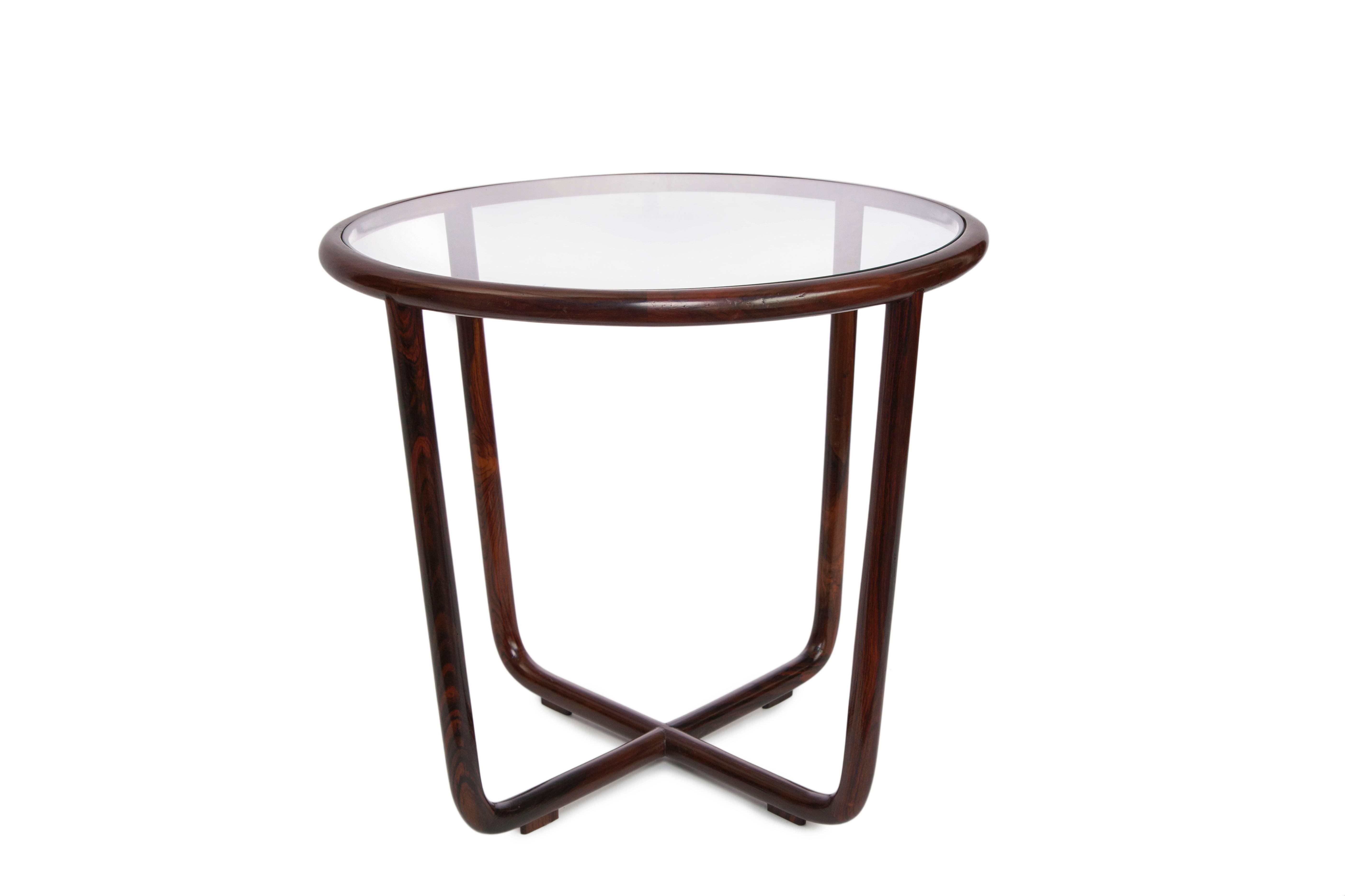 A pair of Brazilian jacaranda wood side tables by Joaquim Tenreiro, produced circa 1950s, with glass tops against round frames in the Minimalist modern style, bases with intersecting legs. Excellent vintage condition, consistent with age and