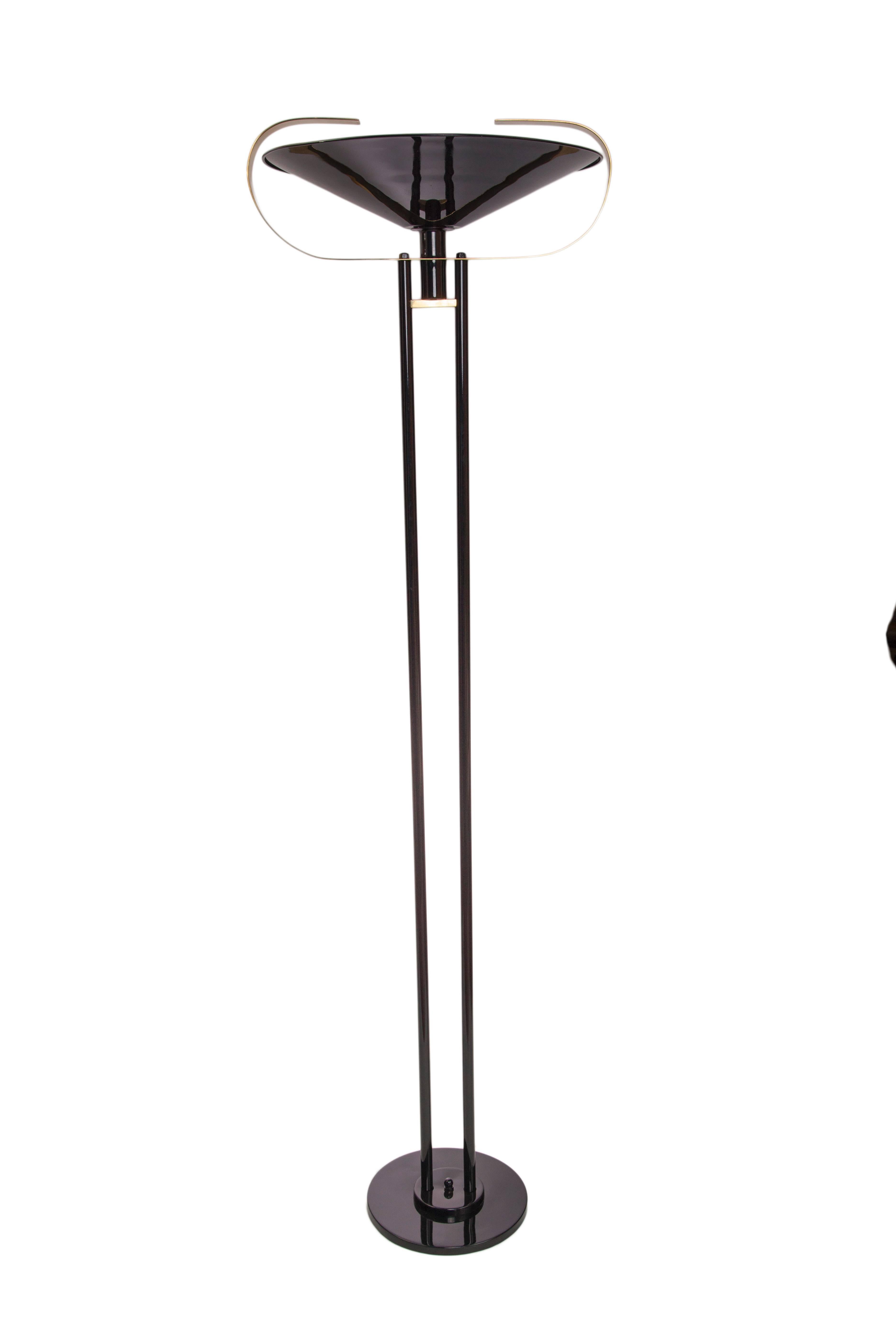 A modernistic torchiere floor lamp, produced circa 1950s in black enameled metal with dual stem, the inverted shade accented with curved brass bands. Very good vintage condition, wear consistent with age and use.