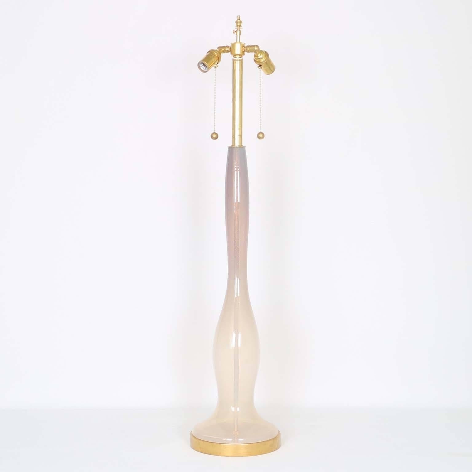 An exceptional baluster form glass lamp by Fratelli Toso, produced circa 1950s Murano Italy, in ombre colors from amethyst to pink opaline with gold infusions. Mounted on a gilded wooden base. The noted height is to the finial, the height to the top