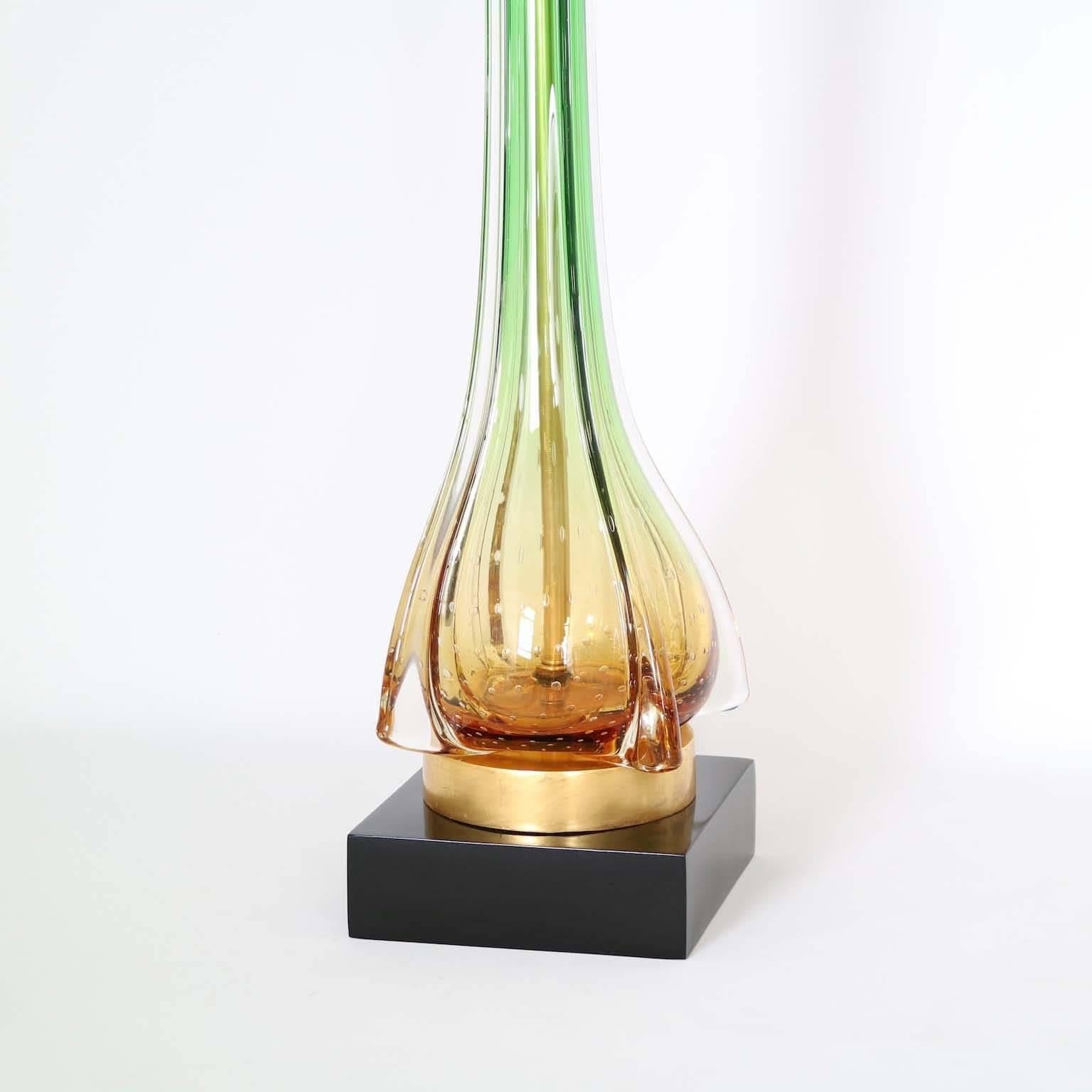 Pair of Mid-Century Modern glass lamps by Seguso in amber-green degrade color, with controlled bubbles at the bottom of the body. Mounted in a new gilded and lacquered wooden bases. The noted height is to the finial. The height to the top of the