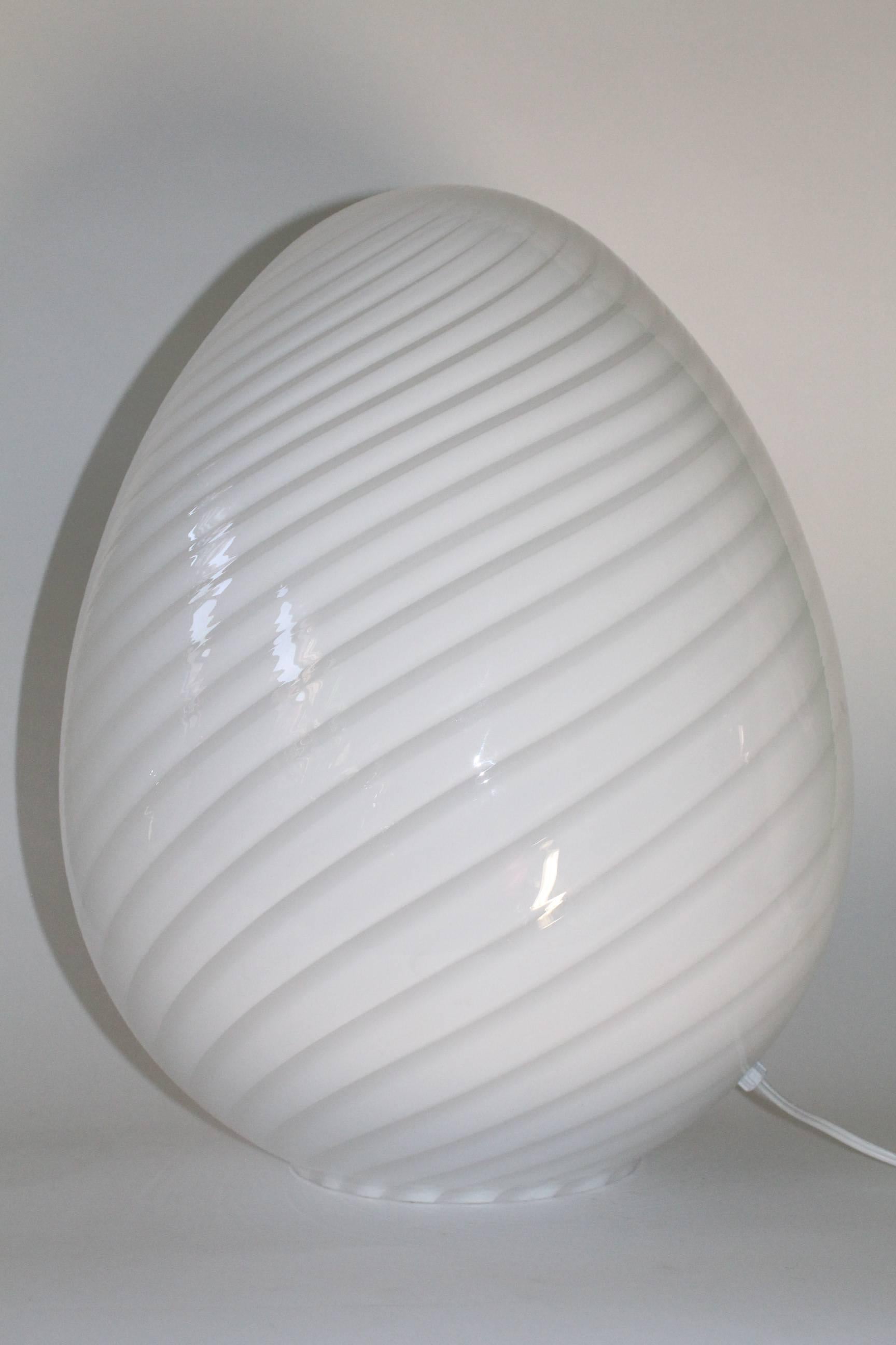 Pair of egg form table lamps with white swirls by Vetri, manufactured circa 1970s in Murano Italy, each including single socket. Markings include sticker label [Vetri Murano]. The vintage lamps remain in mint condition, consistent with age and use.
