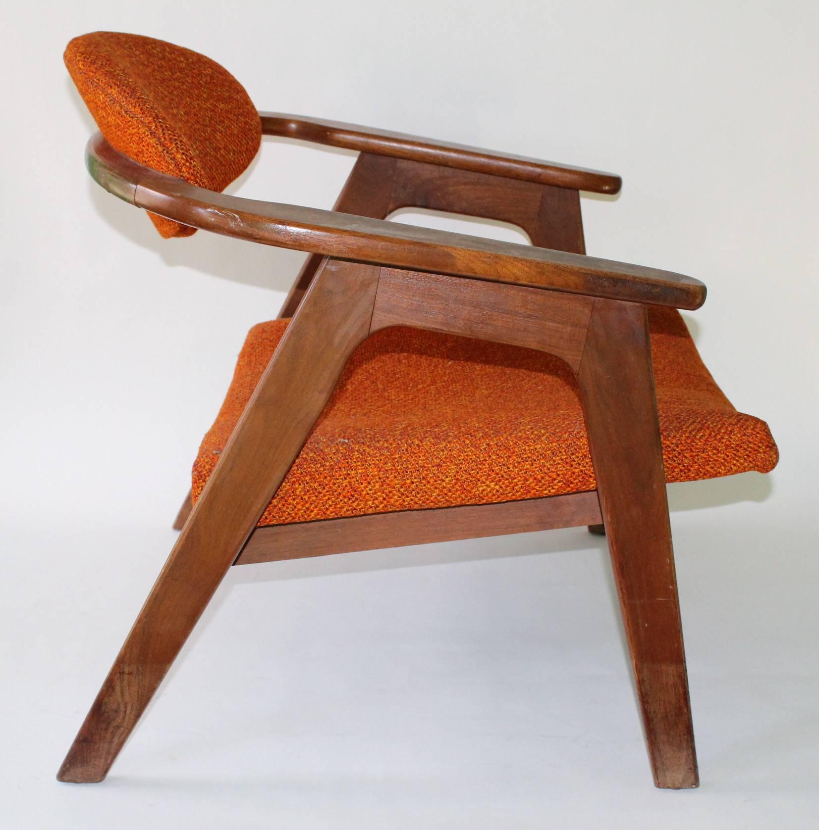 A pair of Mid-Century Modern 'Captain's Chairs' by designer Adrian Pearsall, manufactured circa 1950s, seats and backs with original orange upholstery, against wood frames with round backs, raised on slanted legs. Good vintage condition, consistent