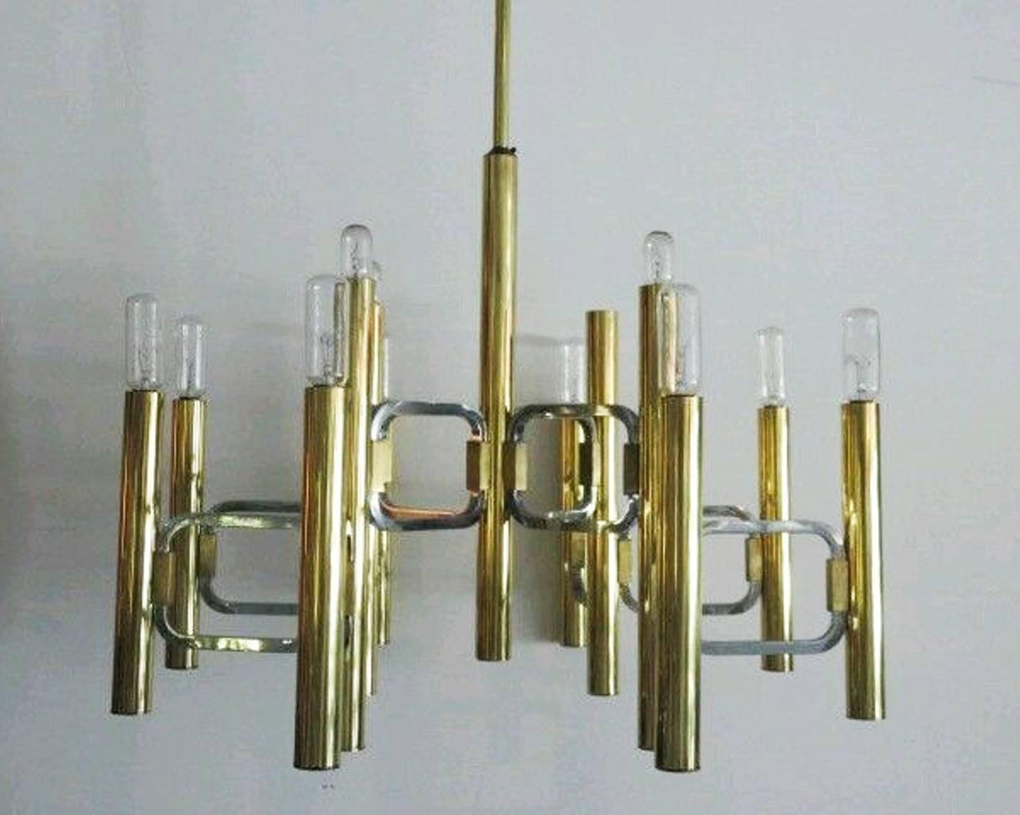 A circa 1960s Italian modern mixed-metal chandelier by designer Gaetano Sciolari, with brass stem and tubular socket covers, detailed with geometric arms in chrome. Includes original [Sciolari] sticker. Very good vintage condition, recently rewired