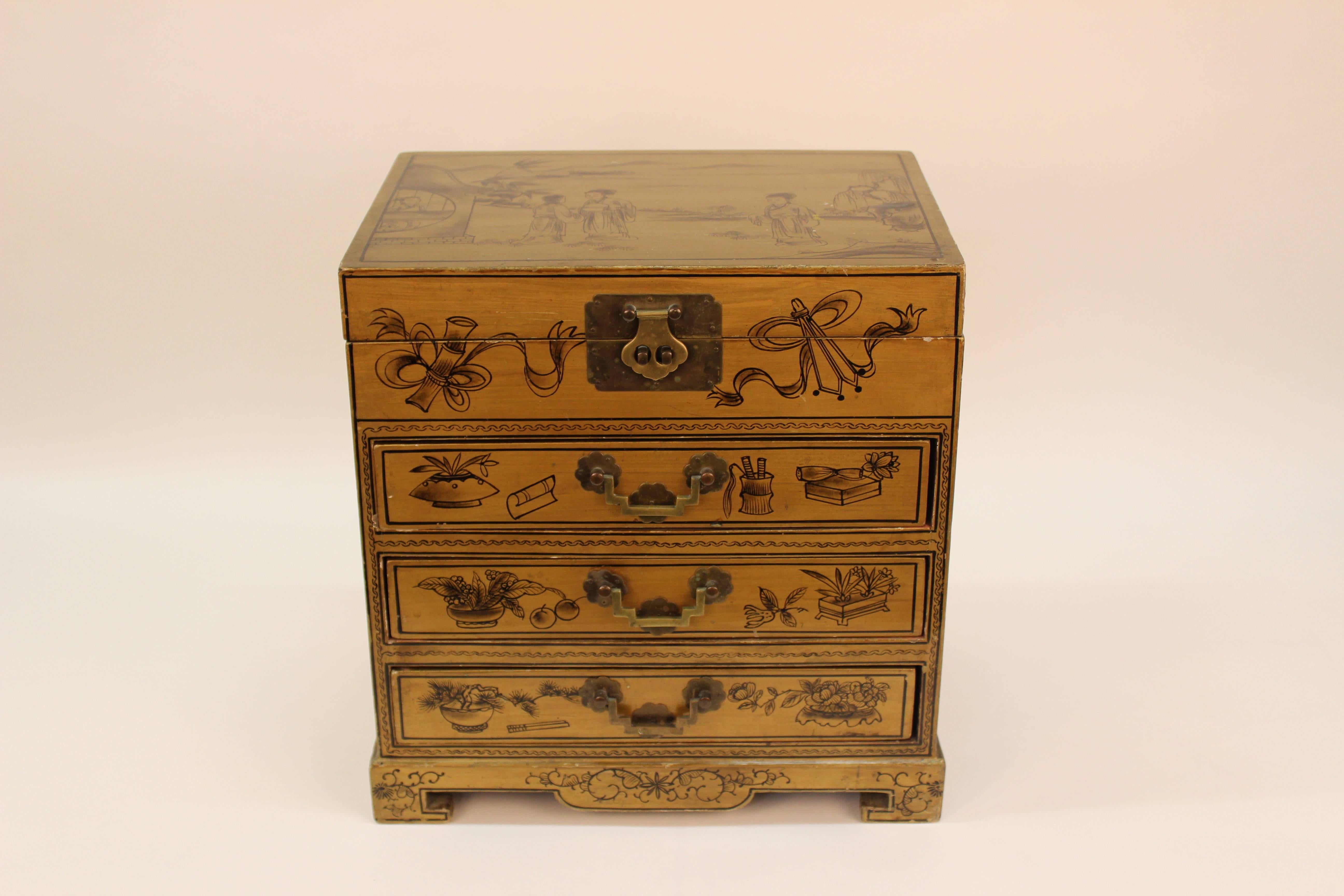 A wooden chinoiserie chest decorated with Chinese beauties in a lovely landscape, with auspicious symbols and peony blossoms. The box is lined with tangerine silk and includes three drawers that hold various configurations for rings and other