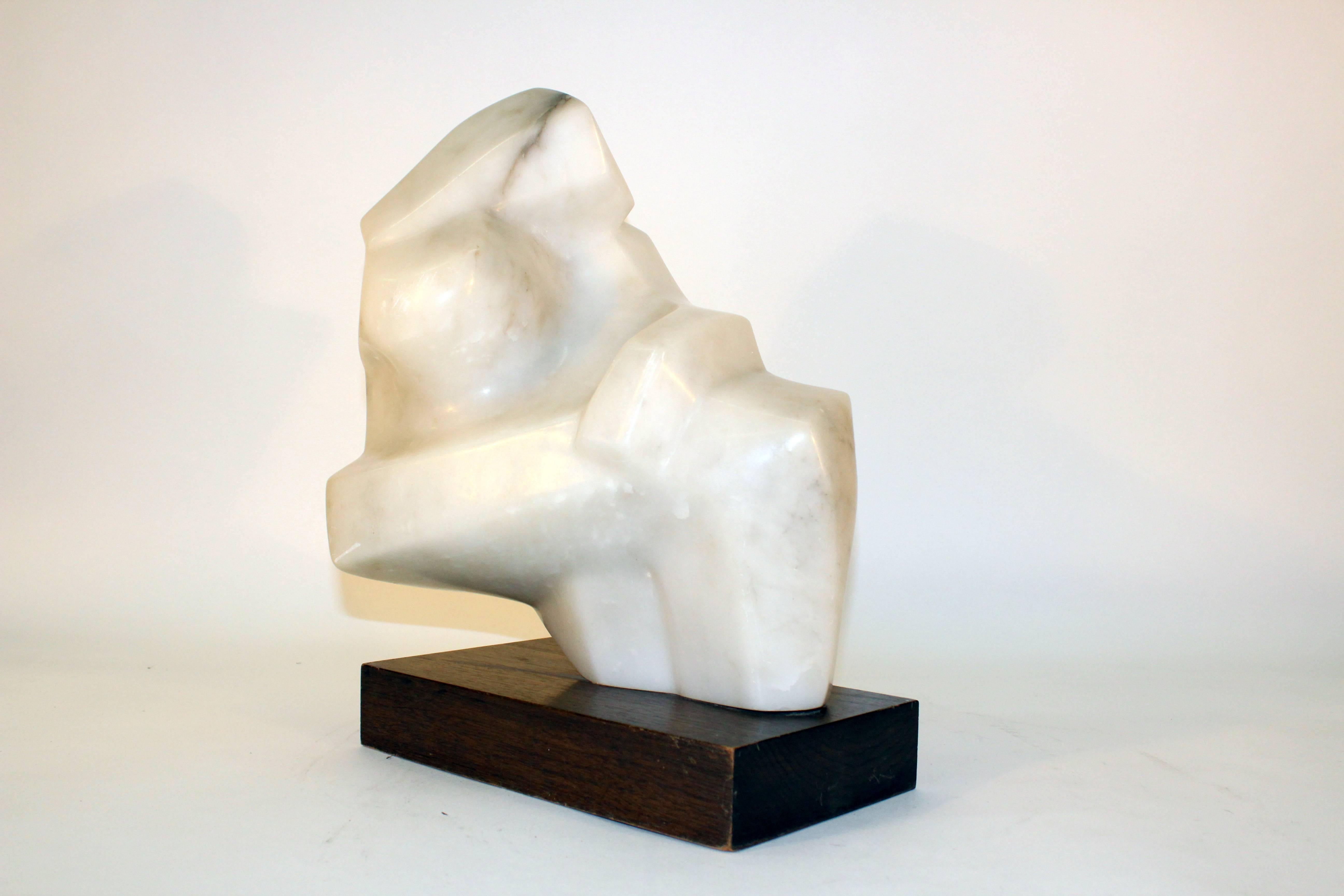 An abstract sculpture carved in alabaster, mounted on a dark wood removable base. The sculpture remains in good condition with some scratches on the base and stone appropriate to use.

110168