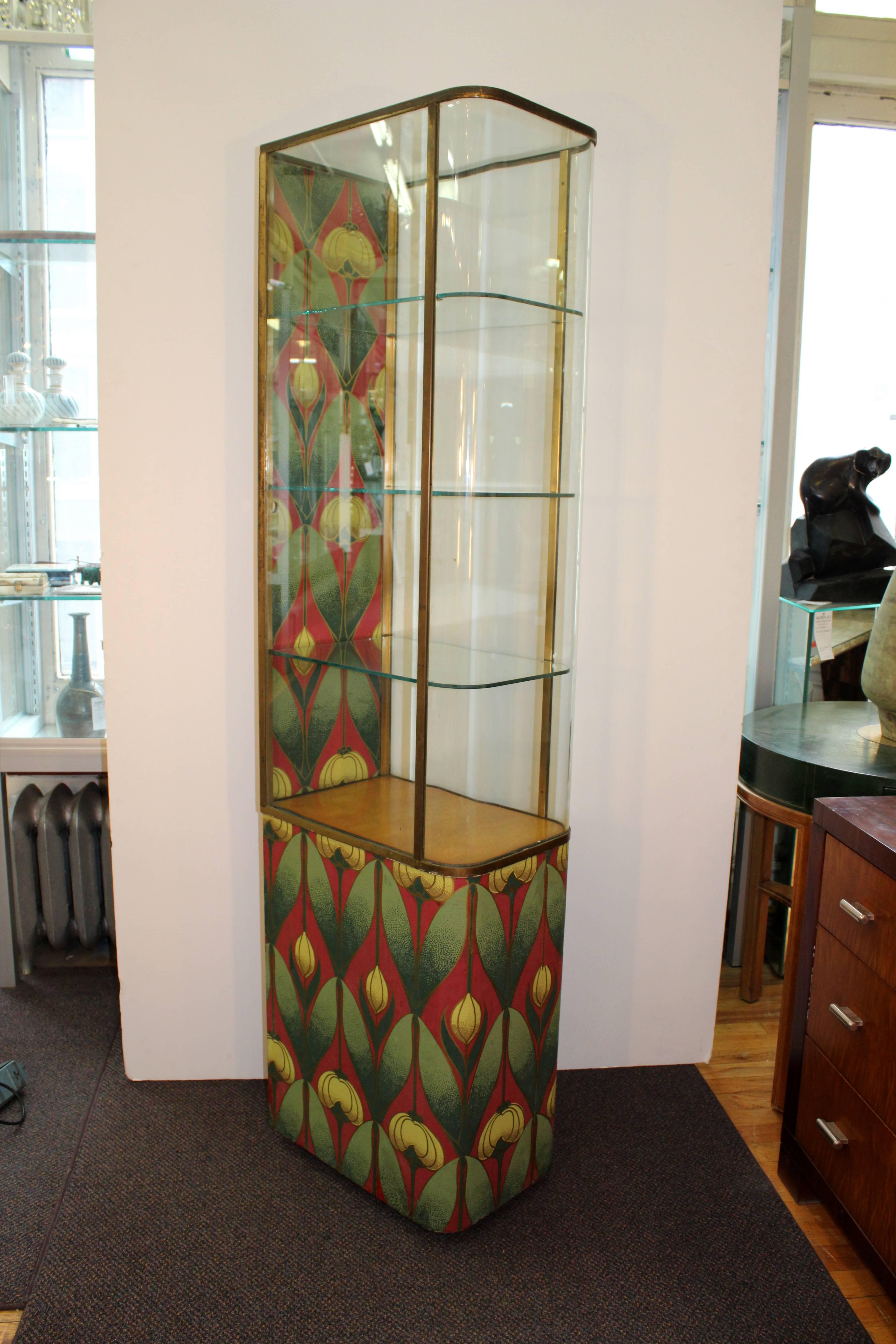 An Art Nouveau Parker Pen glass cabinet with blooming flower pattern in yellow, red and green. Includes three glass shelves, and brass trim, with working lock. Some restoration to the bottom but in overall good vintage condition appropriate to age