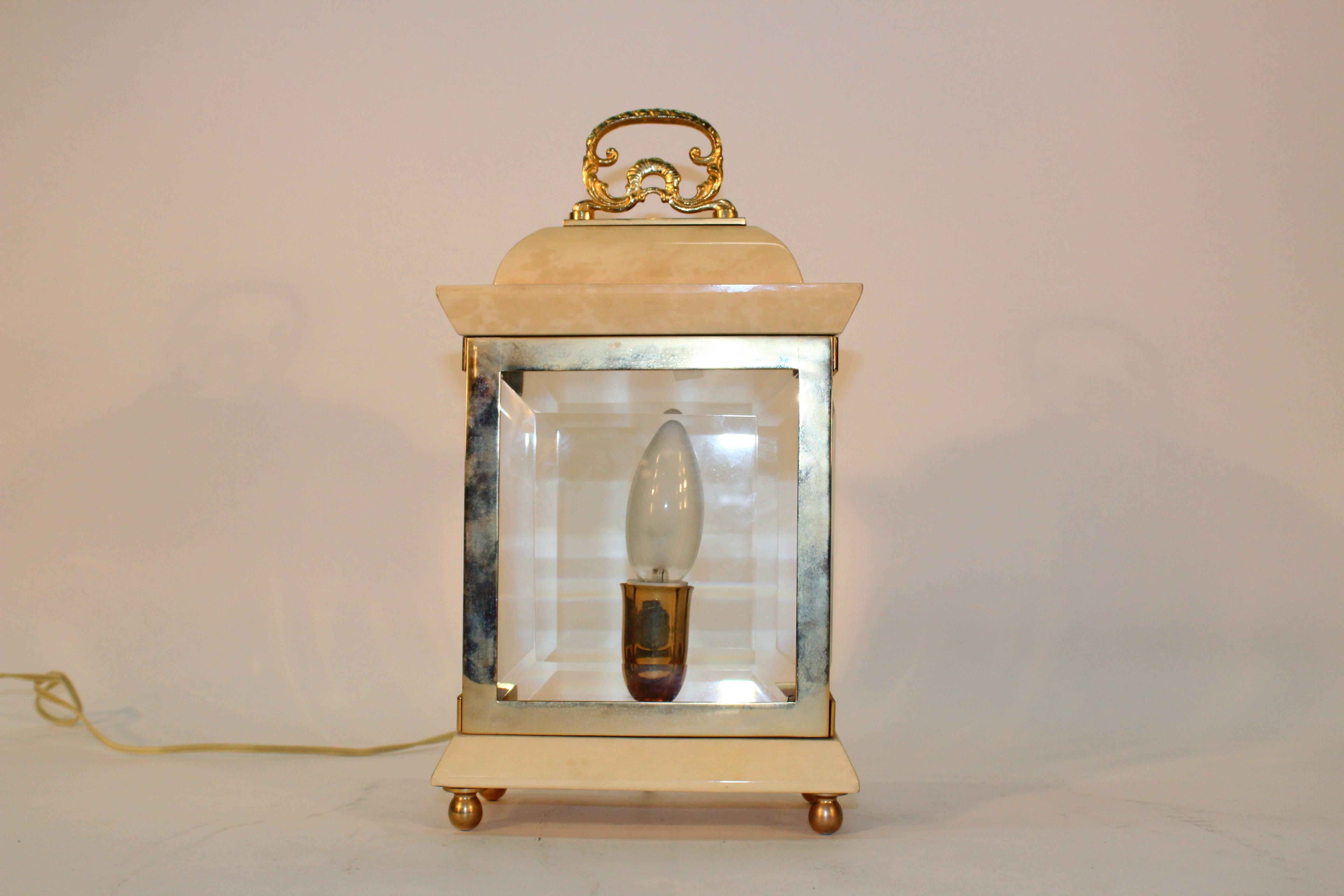 An Italian table lamp in the form of a lantern by Aldo Tura. Crafted in lacquered goatskin, brass and wood, with beveled glass. Includes the original wiring. In overall good condition with wear appropriate to age and use.

110166