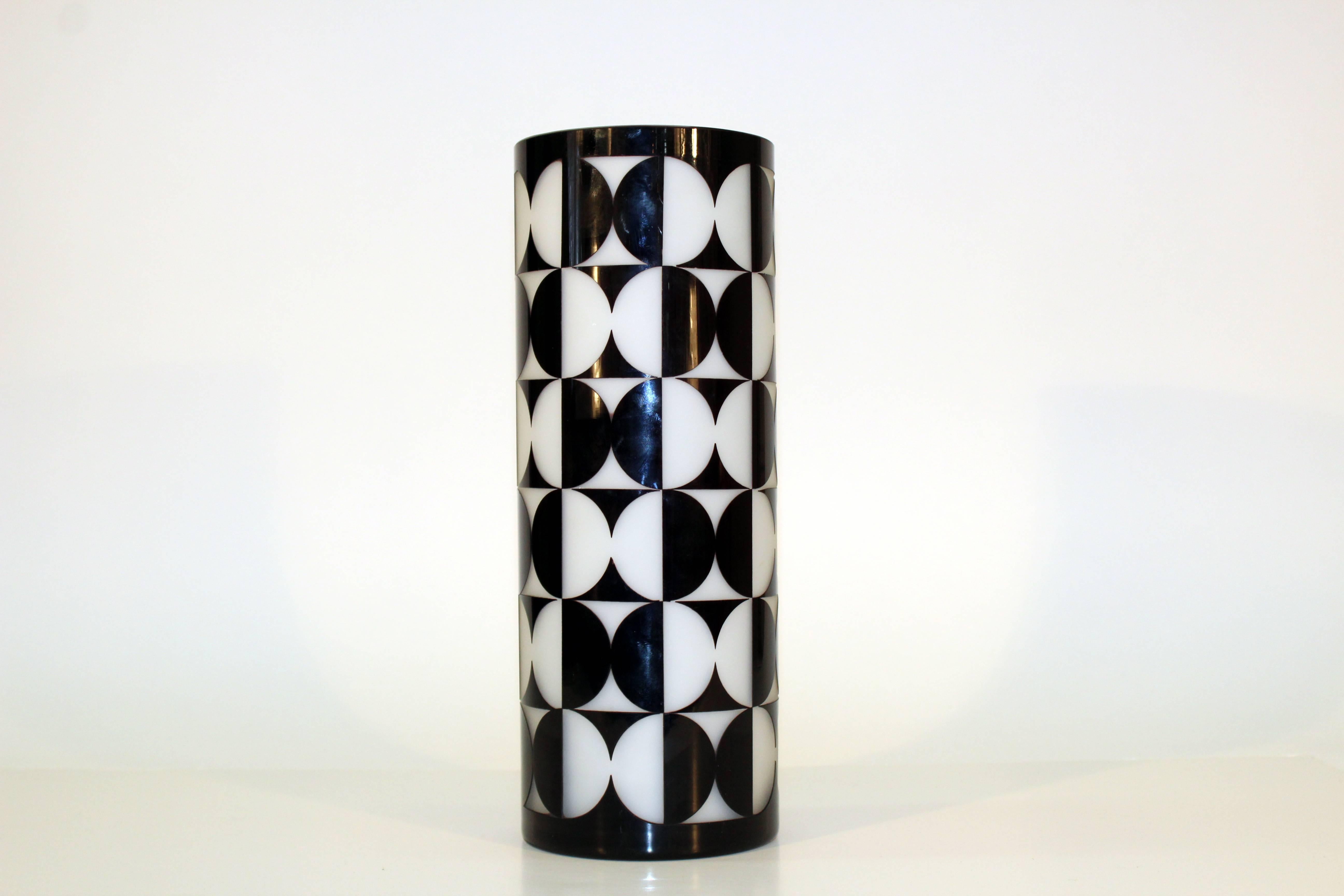 A black over white cased glass vase with carved out Op Art pattern.

110229