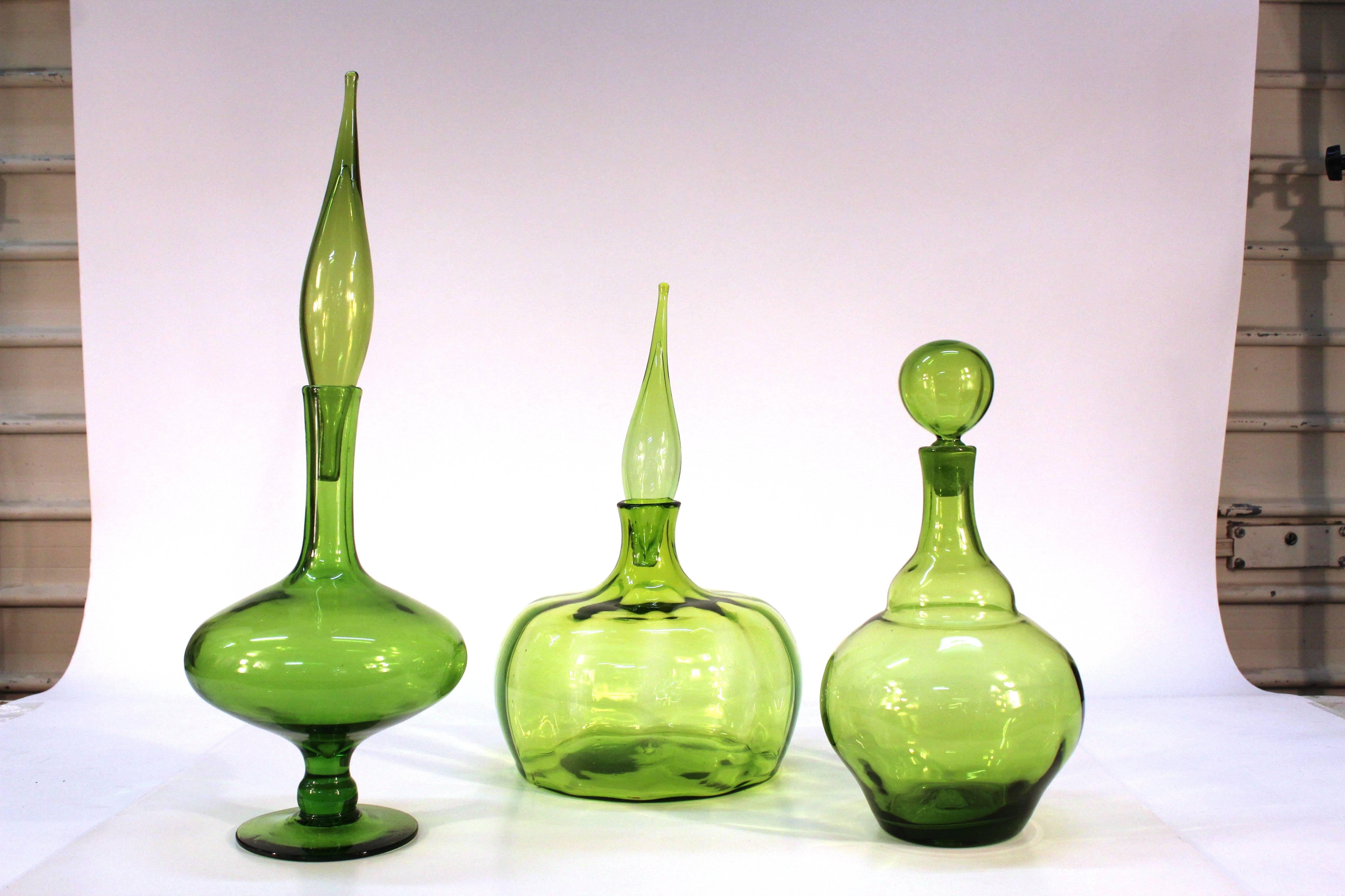 A collection of olive green glass pieces produced by the Blenko Glass Co. of Milton, West Virginia, circa 1960s. Crafted by Joel Myers and Wayne Husted. Each piece is uniquely numbered. Available as a set or individually. 

#15-03-22: Genie