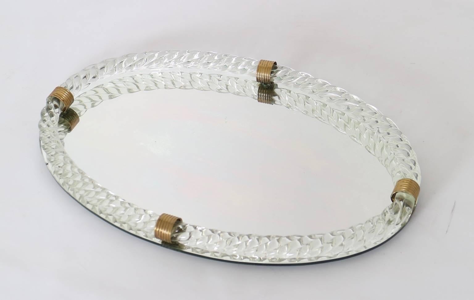 This vintage Murano vanity tray with mirror in oval form features a clear torciglione glass rope gallery with brass accents. In Very good vintage condition, with wear consistent with age and use.

110483.