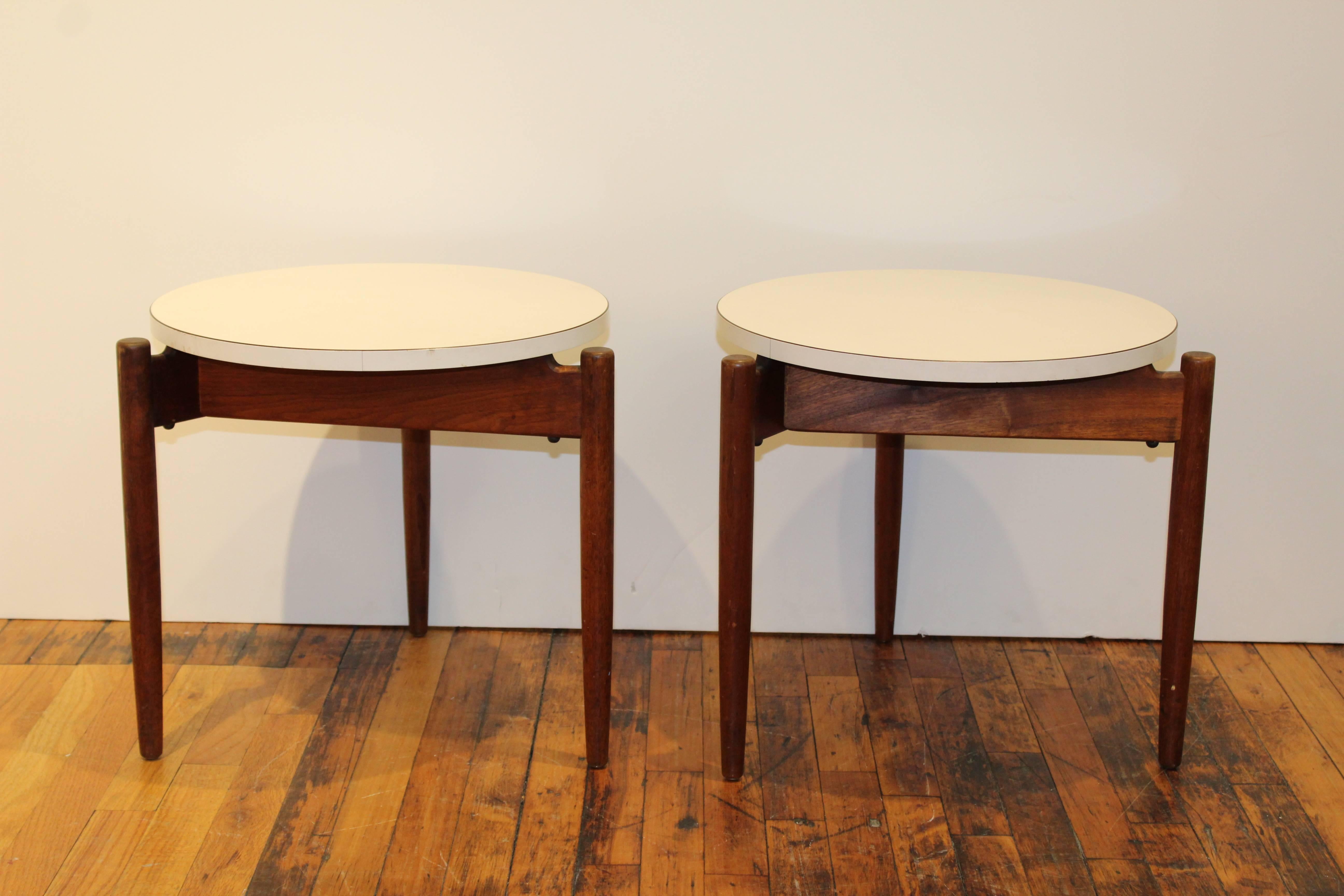 Pair of floating nesting tables by Jens Risom. Styled with circular white tops and teak tripod legs. 

110478