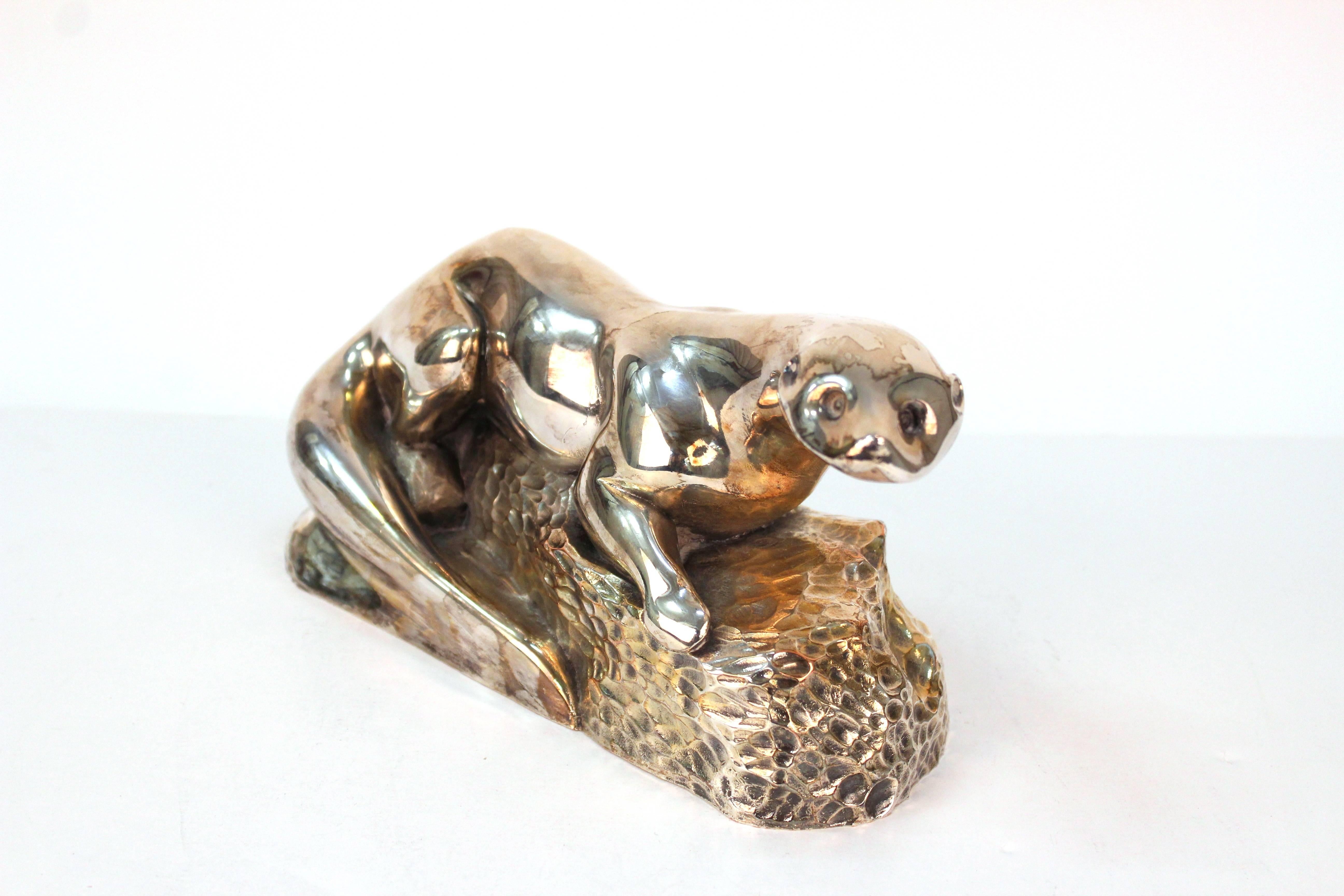 Sculpture of an otter from the mid-20th century Art Deco period, depicted resting on a rock as base, with hammered detail. Markings include artist's signature (albeit indiscernible) to the base. Very good vintage condition, wear to finish consistent