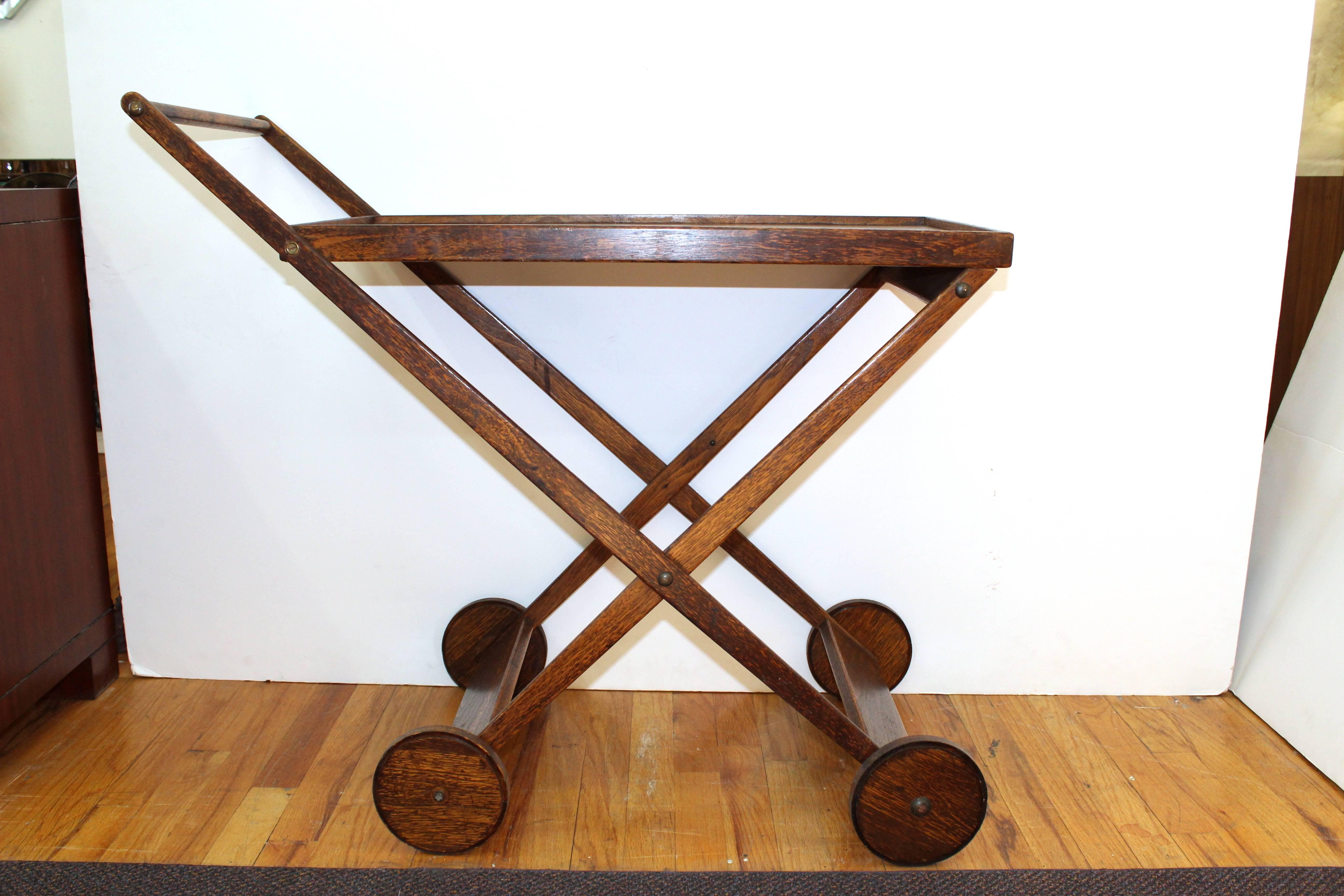 A simple and elegant bar cart by Dennett and Fetz, produced in wood. Makers mark on bottom with some signs of wear appropriate to age and use. 

110437.