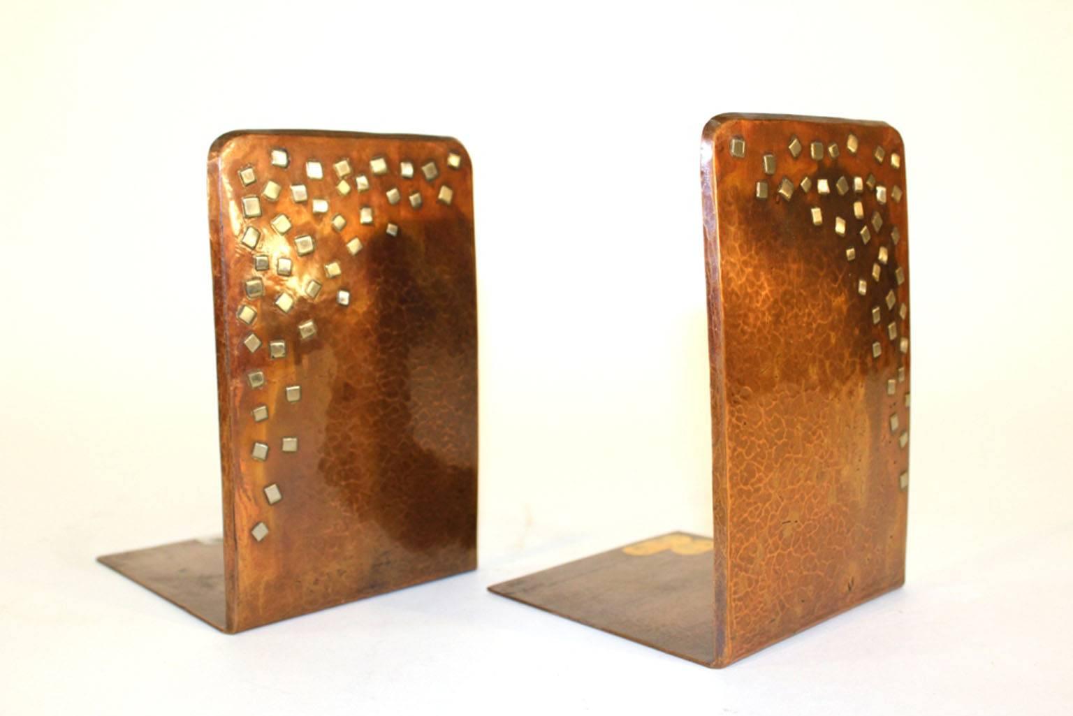 Pair of bookends in copper, polished and hammered. Marked 'Madia' and 'Israel'. Silver accents are present on the surface of each. Each base is labeled. Good vintage condition with age appropriate wear.

110146.