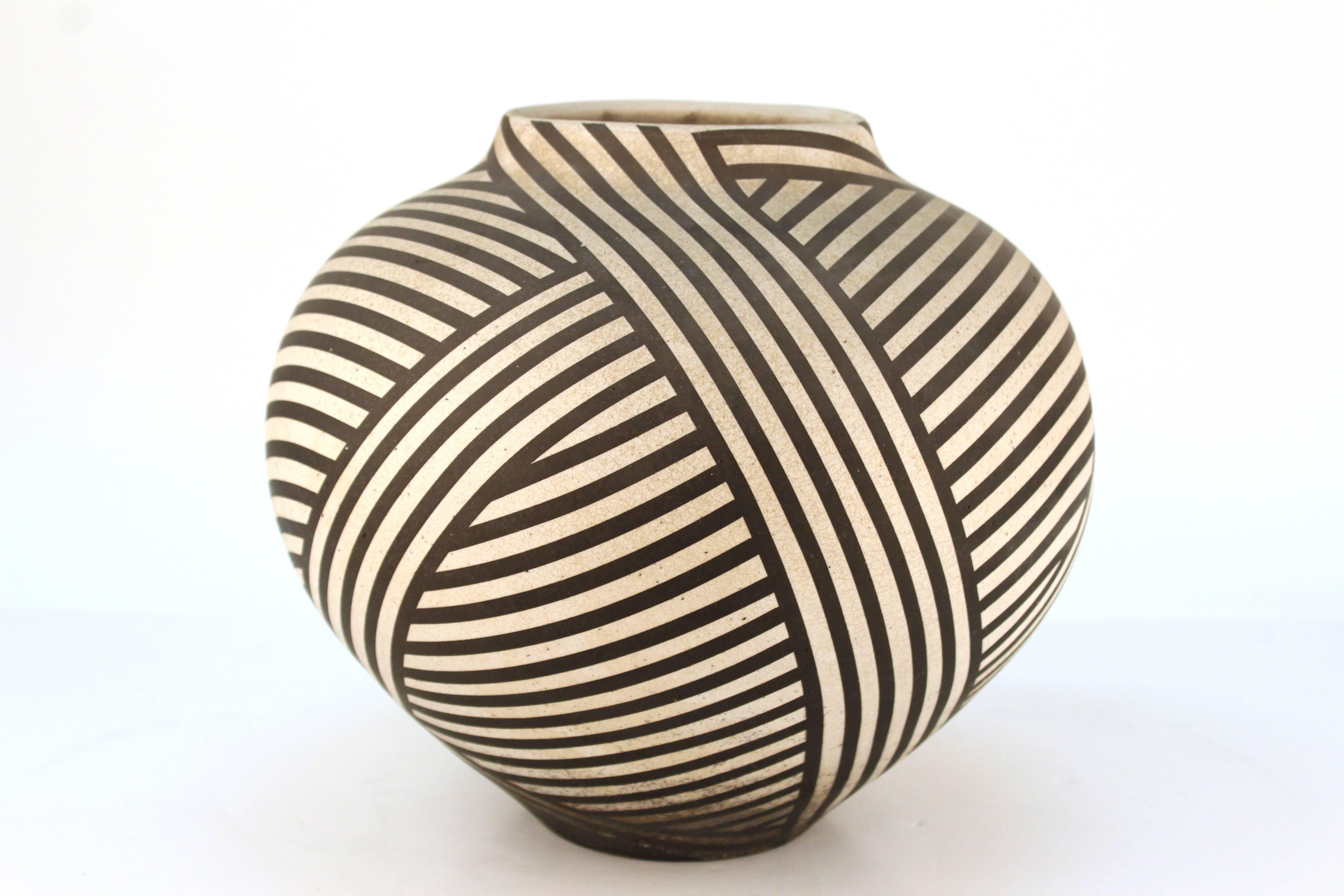 Nicholas Bernard ceramic vessel with crisscrossing layers of stripes in cream and black. Signed on bottom.

110577.