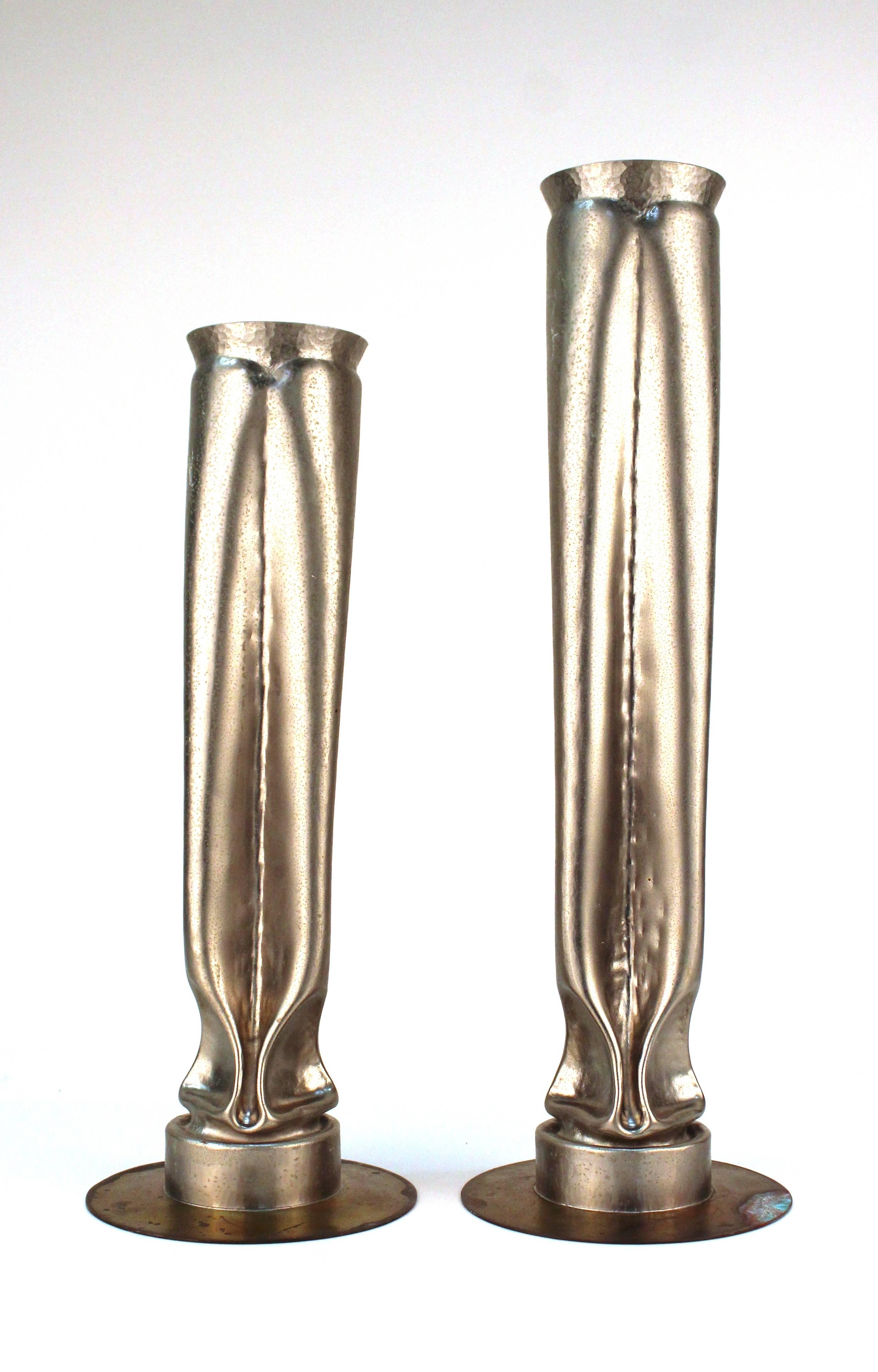 Pair of Brutalist manner vases of unmatched heights designed by Thomas Roy Markusen, produced circa 1980s, each crafted of metal with nickel plate finish, flared rim body stylistically warped and folded, on circular flat bases. Markings include