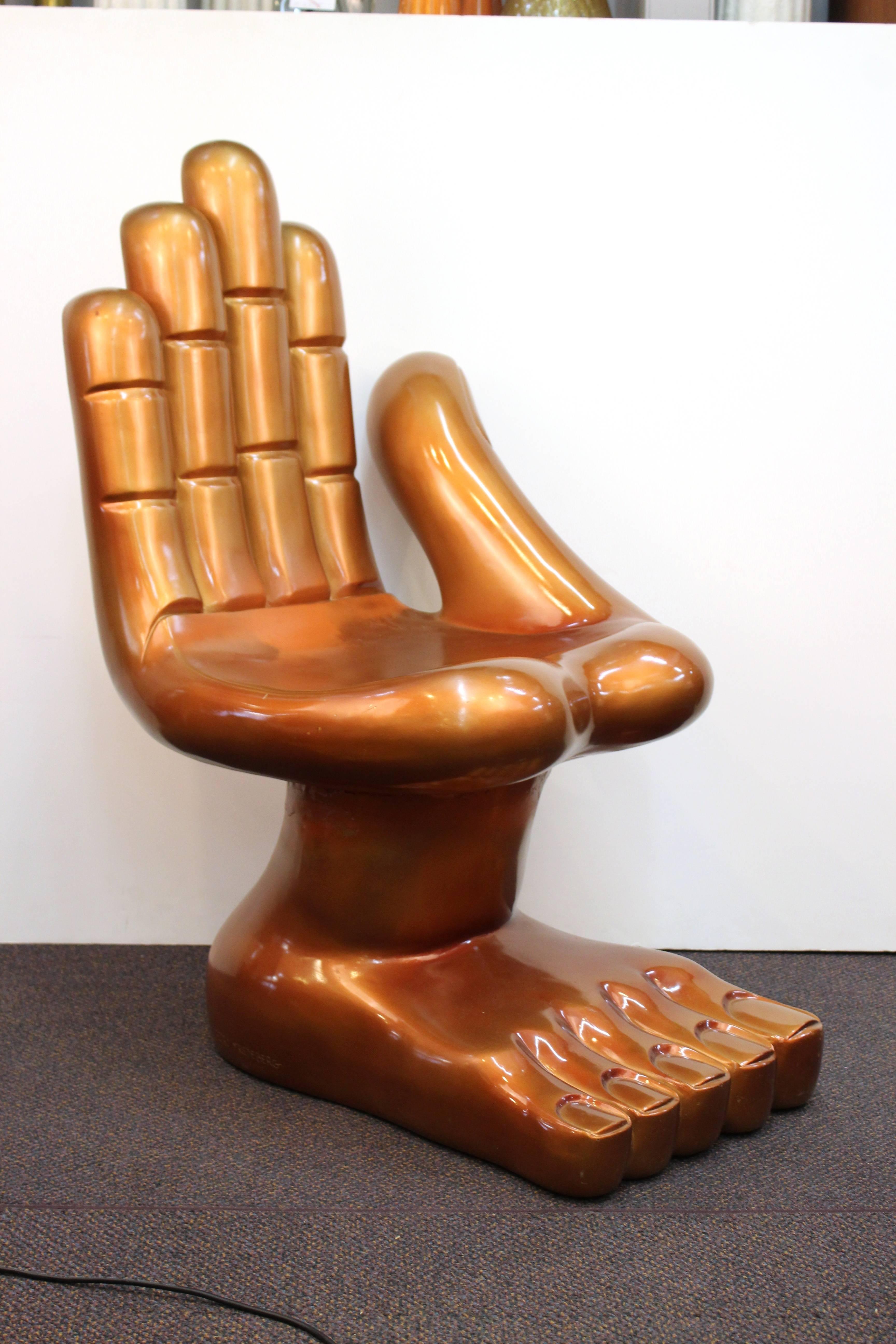 A humorous chair by Pedro Friedeberg with a hand for a seat and a foot for legs produced in a burnt orange fiberglass. Despite some minor wear to the top finger and the side of the palm, the chair remains in very good condition. 110631
  