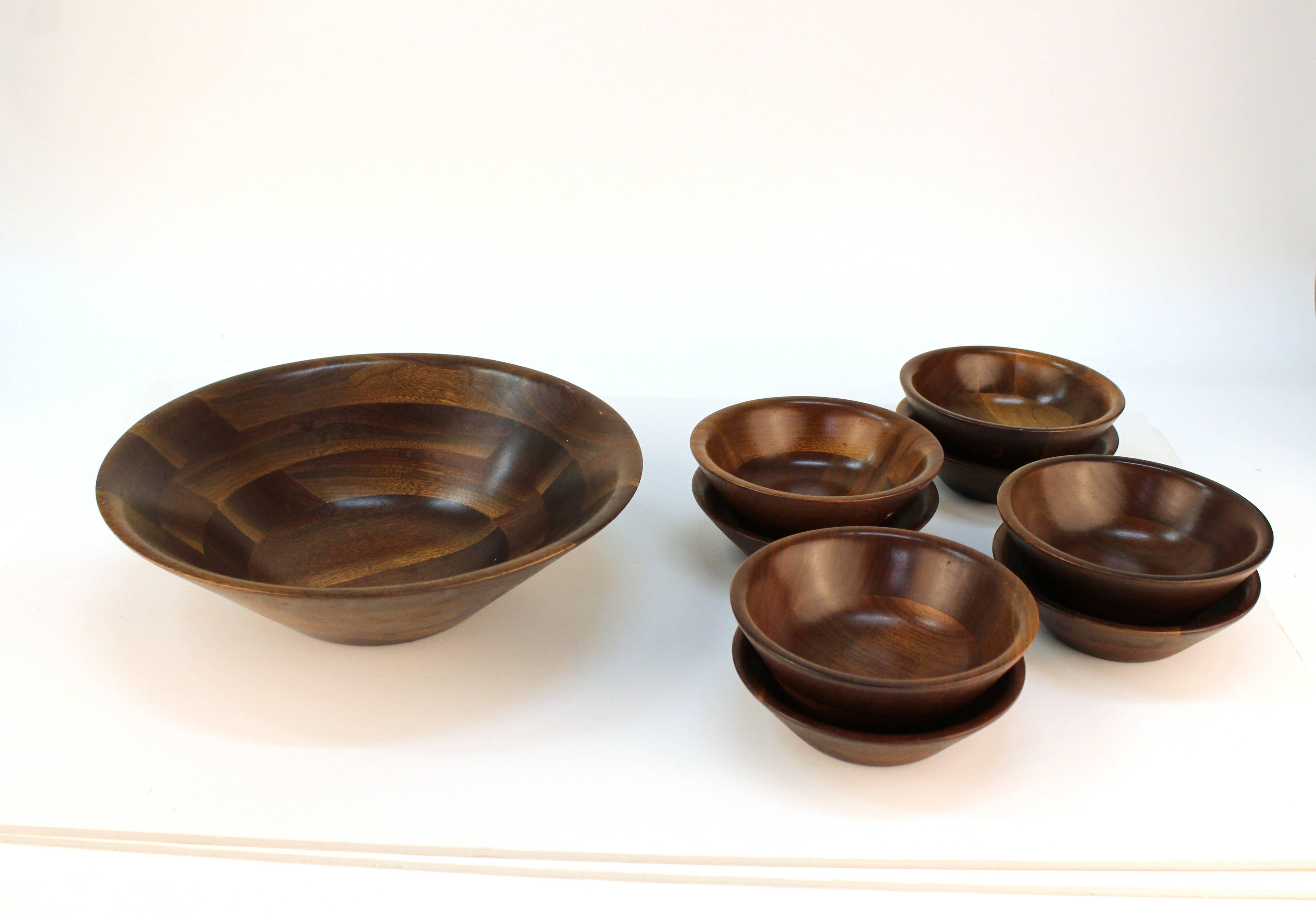 A set of Vermilion walnut bowls. Includes one large salad bowl and eight serving plates. Despite some minor wear, the set remains in over all good condition. 

Measures: Large bowl dimensions: 3