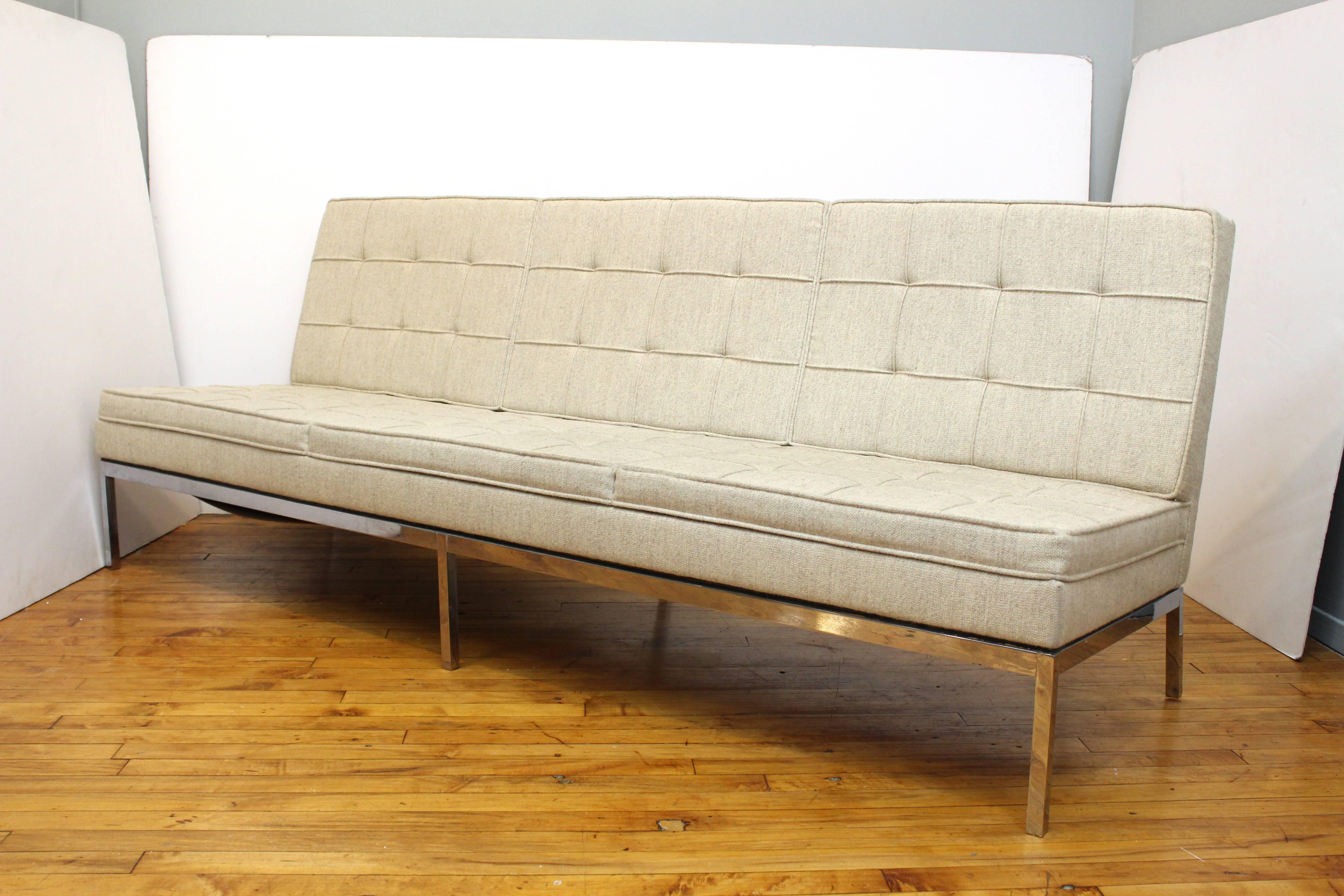 A three-seat sofa by Florence Knoll for Knoll. Classic Mid-Century design in chrome, with tufted and box stitched cream fabric. Includes original Knoll label on base. 
 110714.