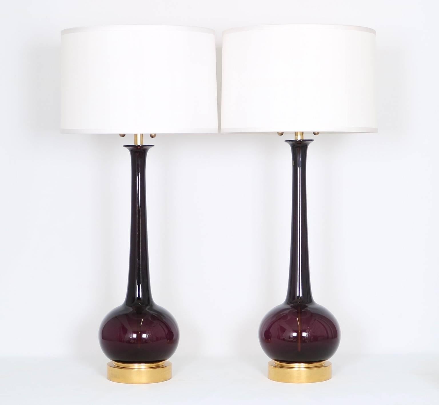 Pair of Mid-Century Modern Murano long-neck glass lamps by Seguso in a deep amethyst color for Marbro. Mounted on gilded wooden bases. Includes the original sticker ” Venetian Glass.” The noted height is to the finial, the height to the top of the