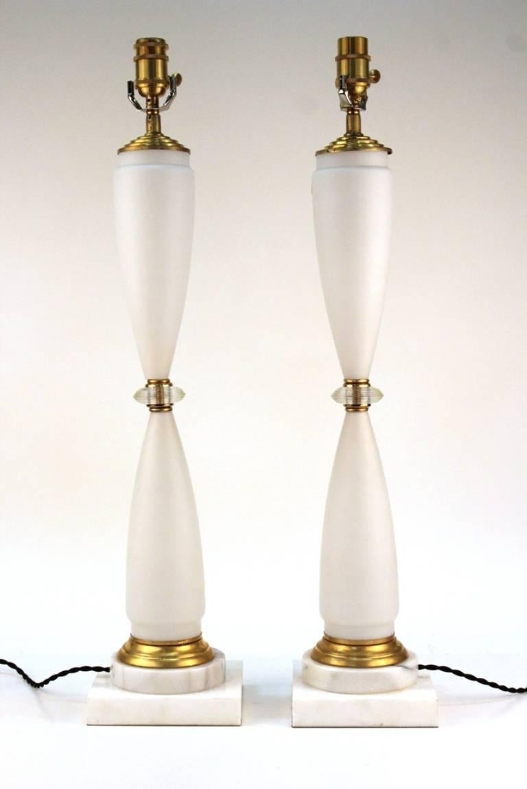 Pair of German Mid-Century lamps in matte white glass with gilt metal accents and white marble bases. 