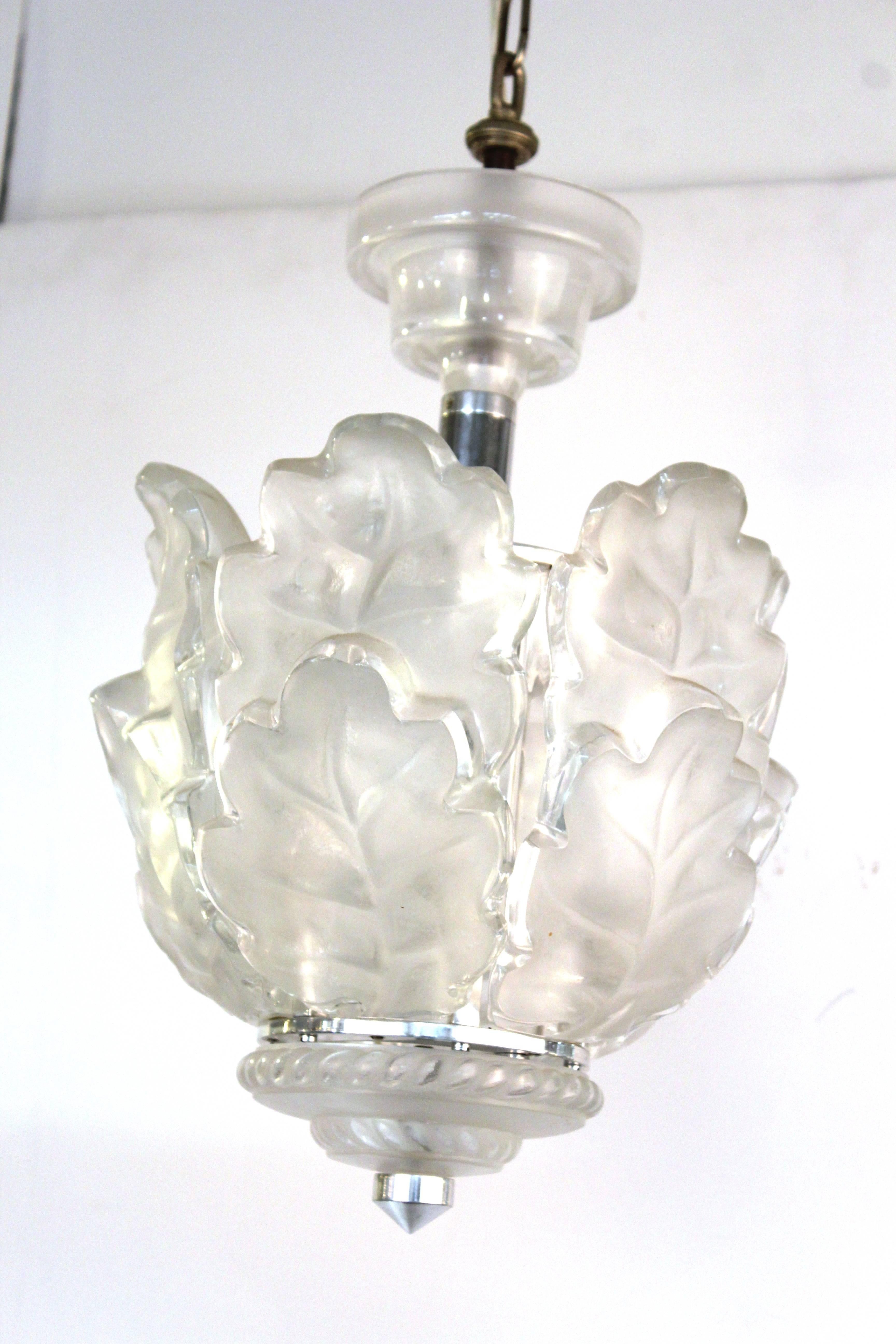 A ceiling pendant by Lalique from the "Chene" or oak collection characterized by its overlapping frosted glass leaves.