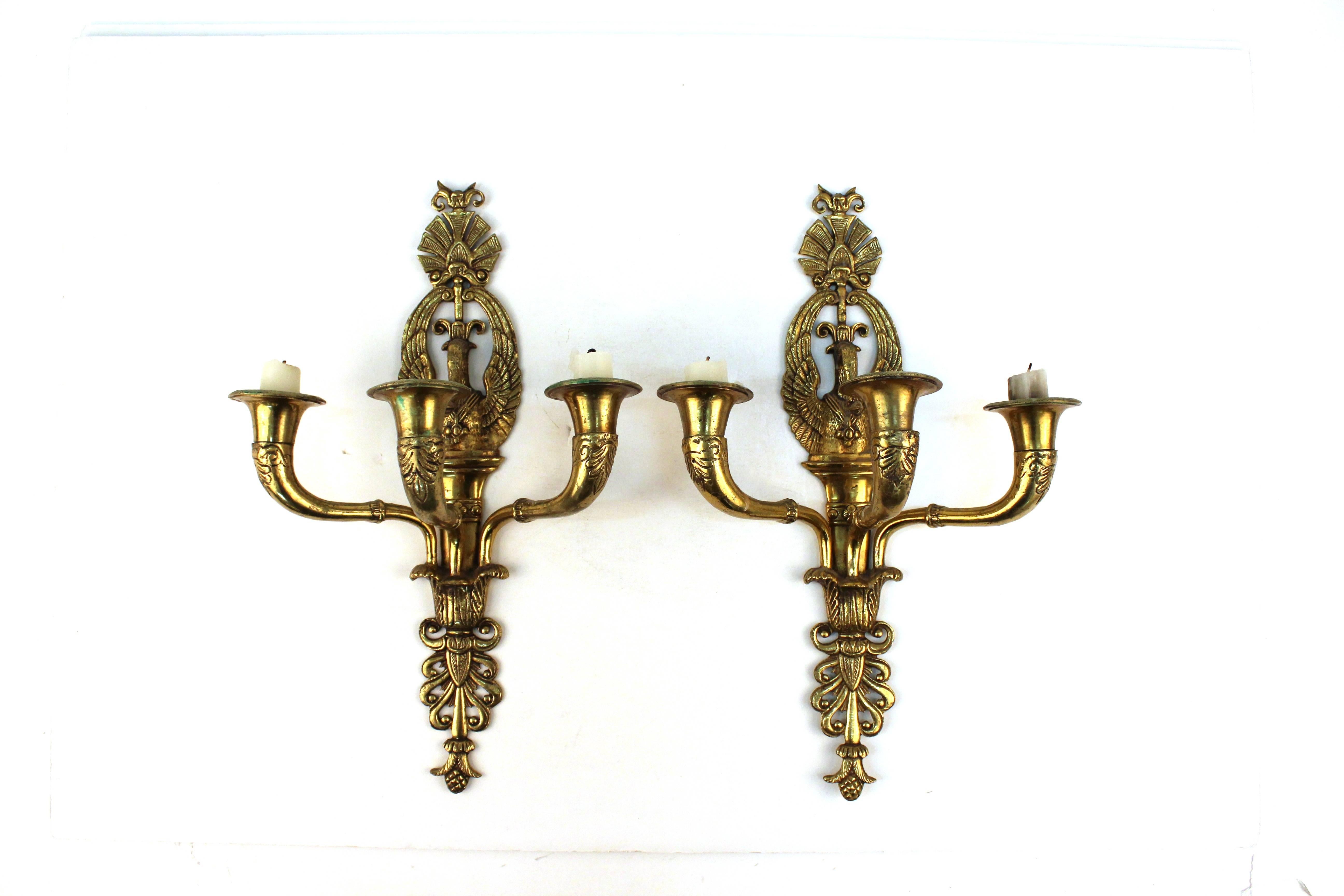 A pair of French Empire sconces from the 19th century featuring a swan motif and three candleholders.