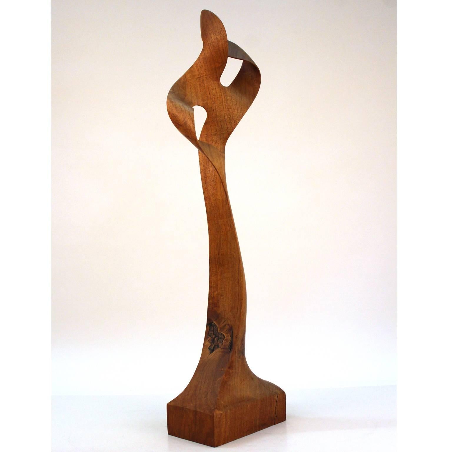 A modernist carved wood sculpture by American architect and artist Thomas E. Woodward (1932-2011). The sculpture appears to be made in American walnut and finishes at its top into a double Mobius band. Excellent original condition, signed on bottom