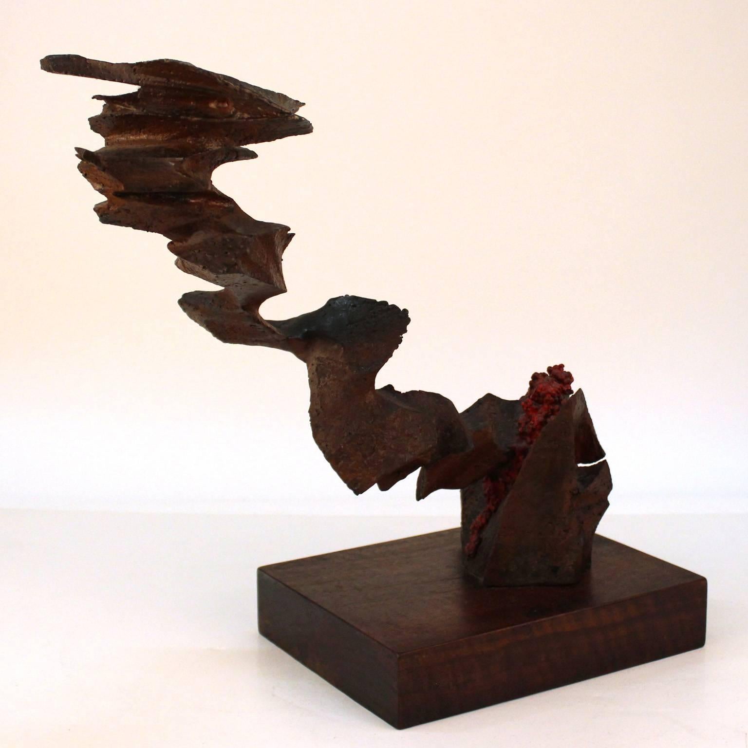 A Brutalist abstract sculpture by American artist Mike Feeney, made in the mid to late 20th century circa 1970s in cast and carved patinated bronze atop a wooden base. Good original condition. Label on bottom marked 