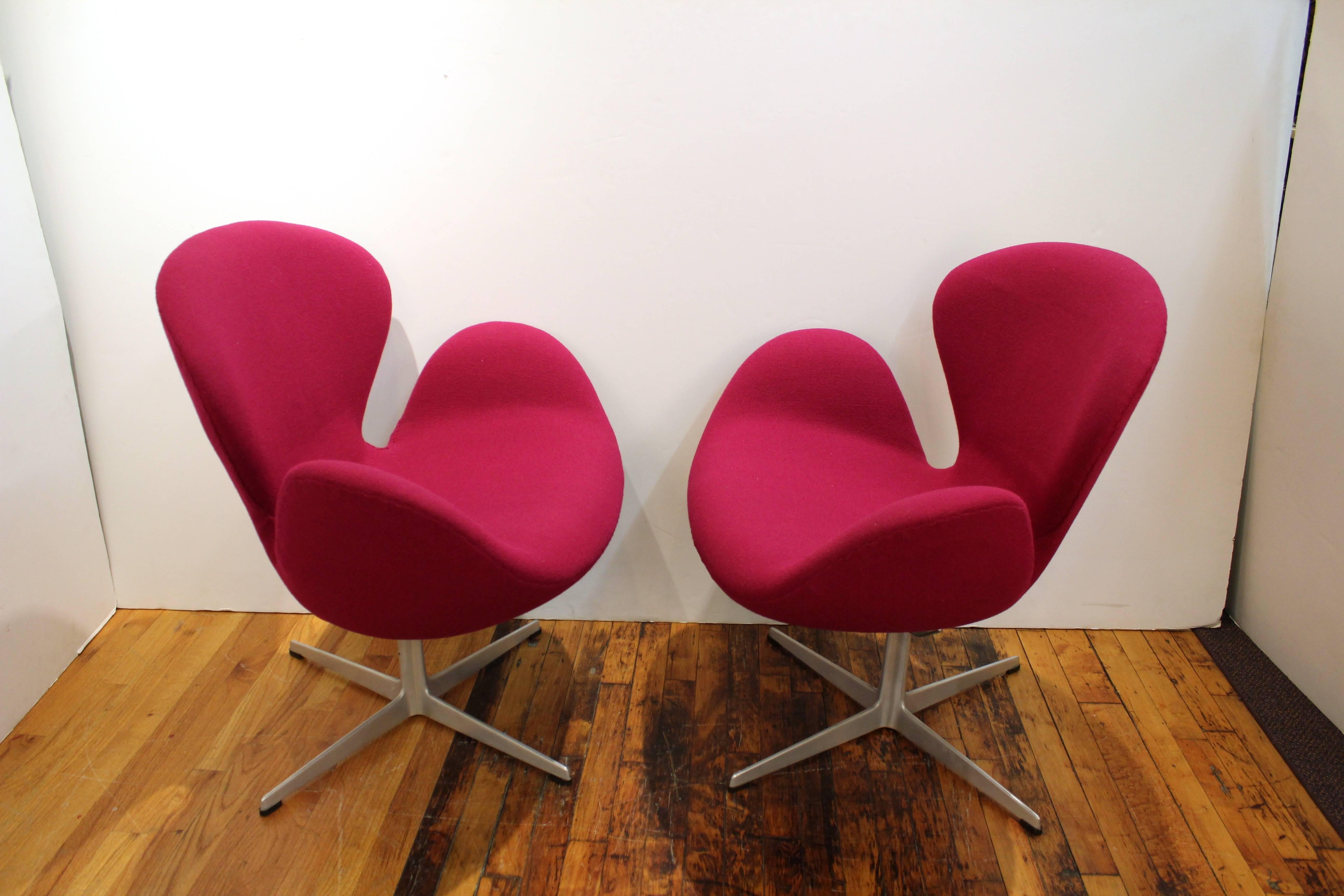 Arne Jacobsen mid-century modern swan chairs with a swivel base produced for Knoll newly reupholstered in bright pink fabric. This chair is in good vintage condition and has wear consistent with age and use. 