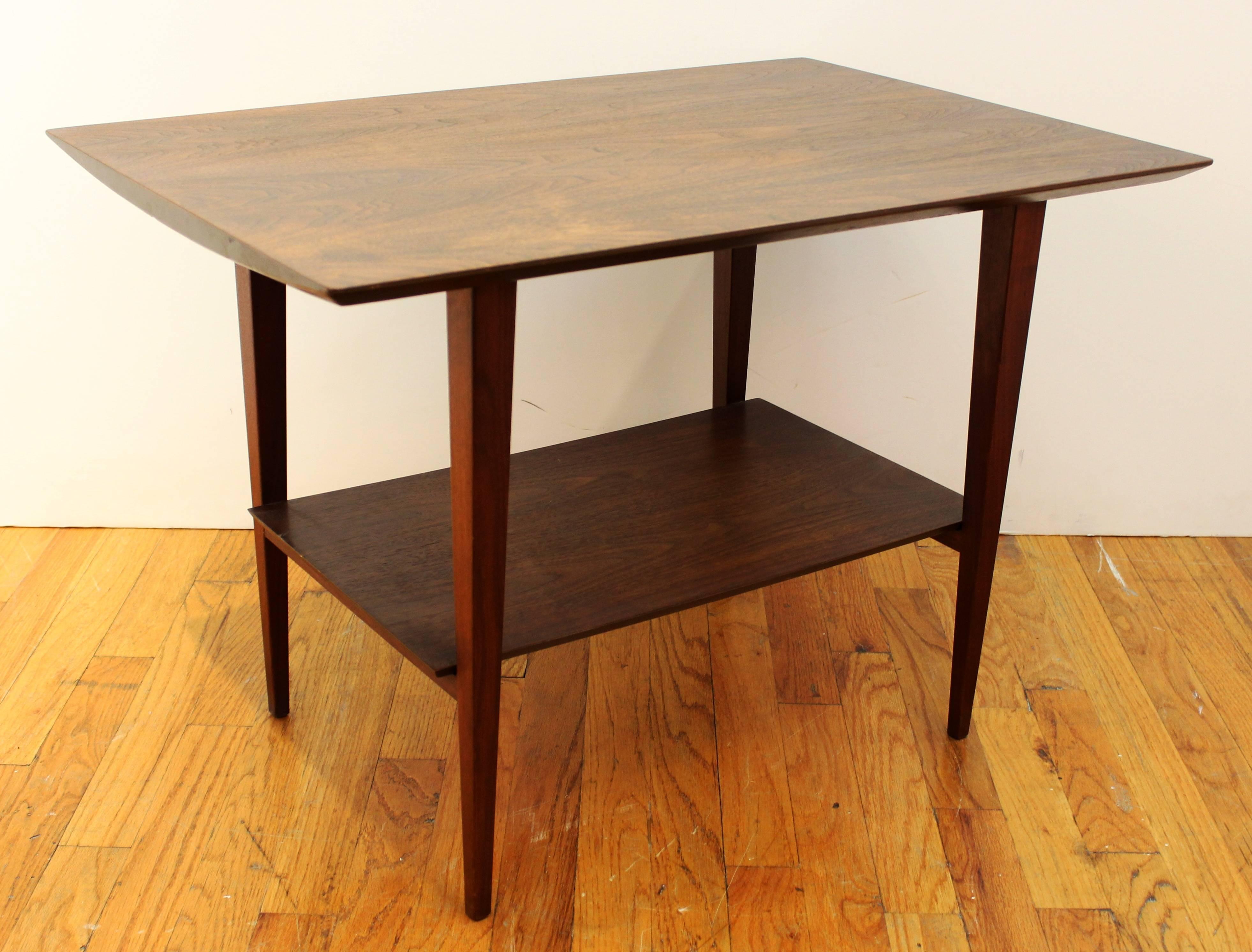 A Mid-Century side table in teak with a single shelf below the top and bevelled edges in the Scandinavian Modern style. In good vintage condition consistent with age and use. 110883.