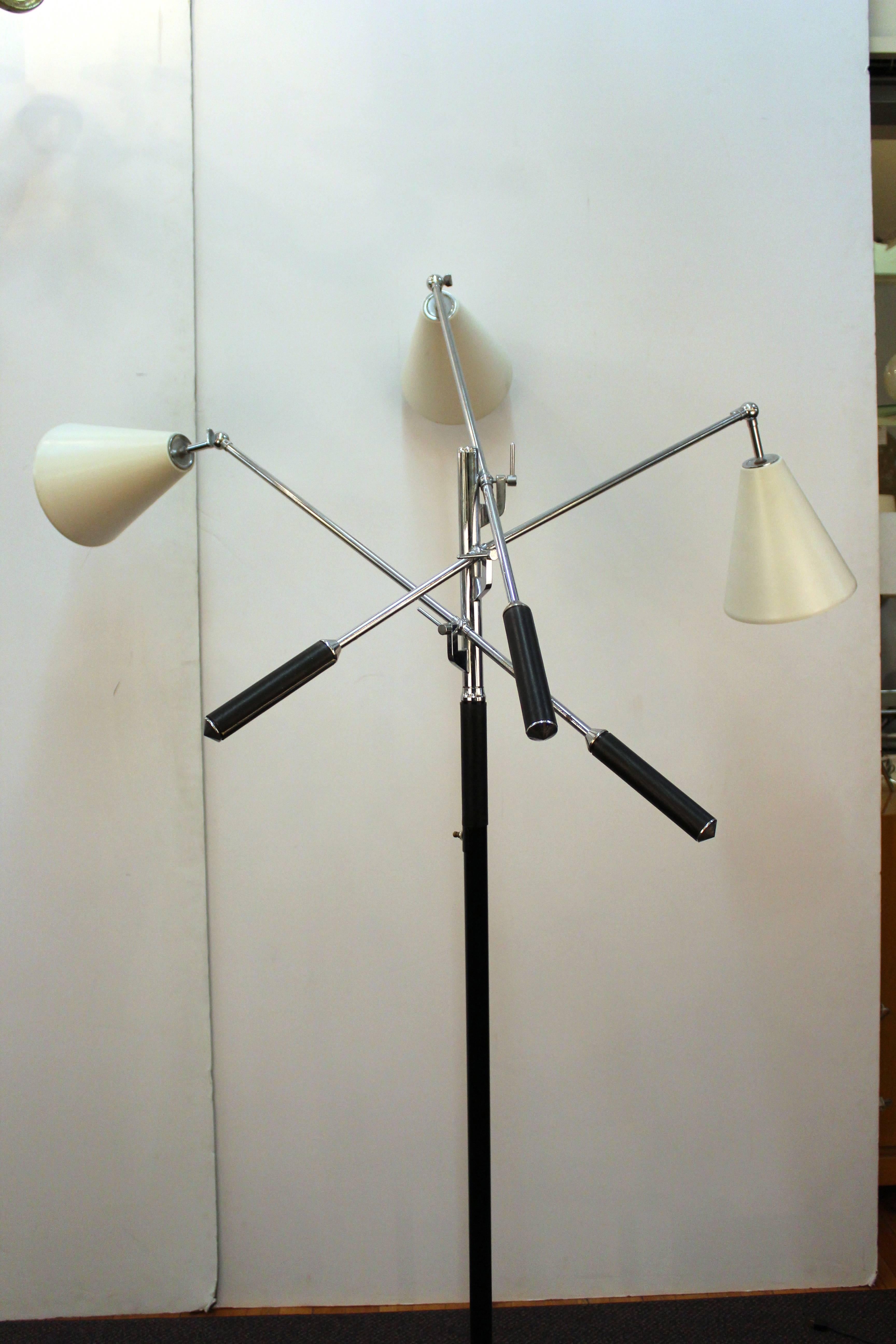 Iconic Mid-Century 1960s style of Arredoluce and style of Angelo Lelli Triennale three arm floor lamp with white metal shades. Adjustable chrome arms and shaft marble base with black leather accents. Includes a three way switch and adjustable