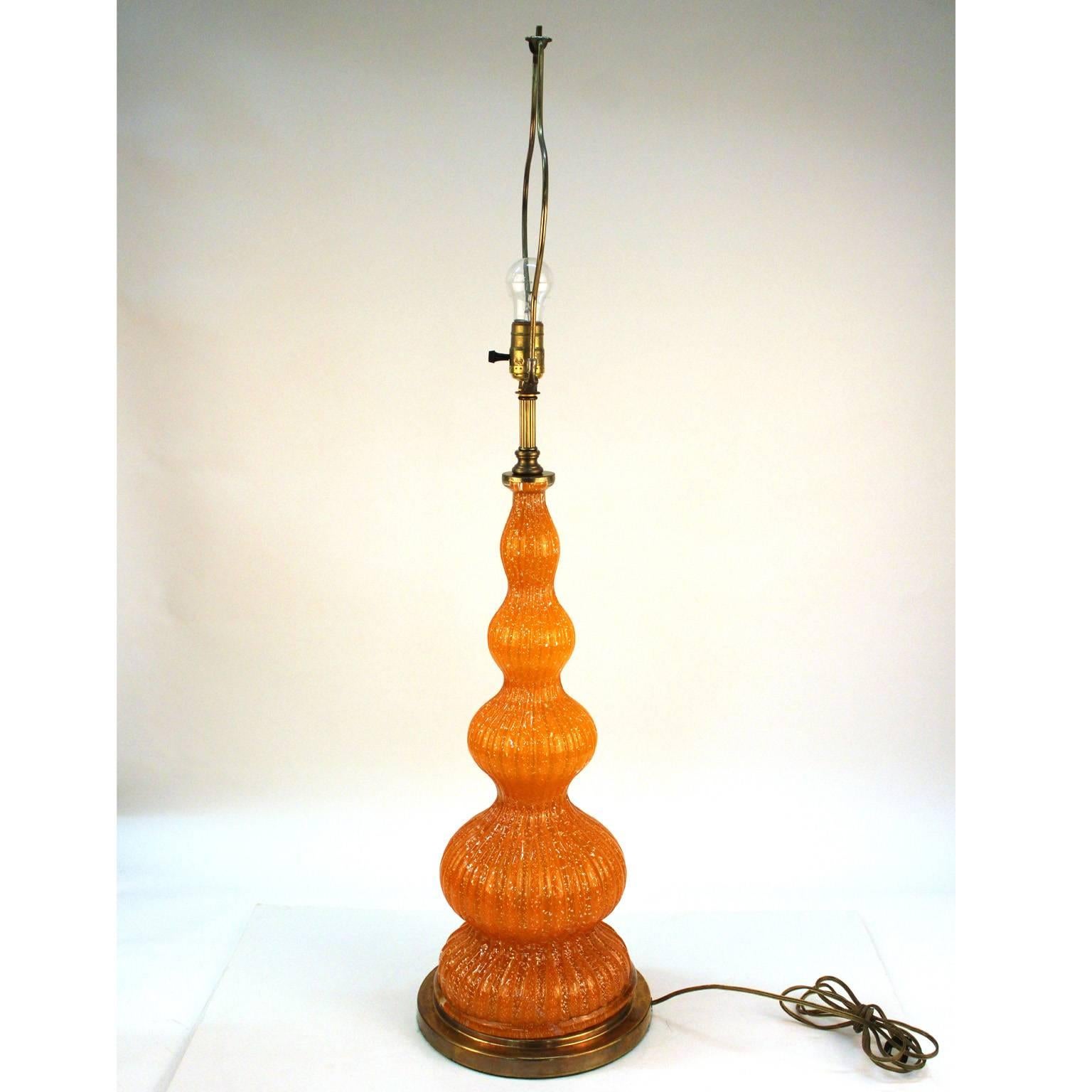 A Mid-Century 1950s Murano glass table lamp made by Barovier and Toso in Italy. Handblown rare orange glass with white gold flecks and brass ware.