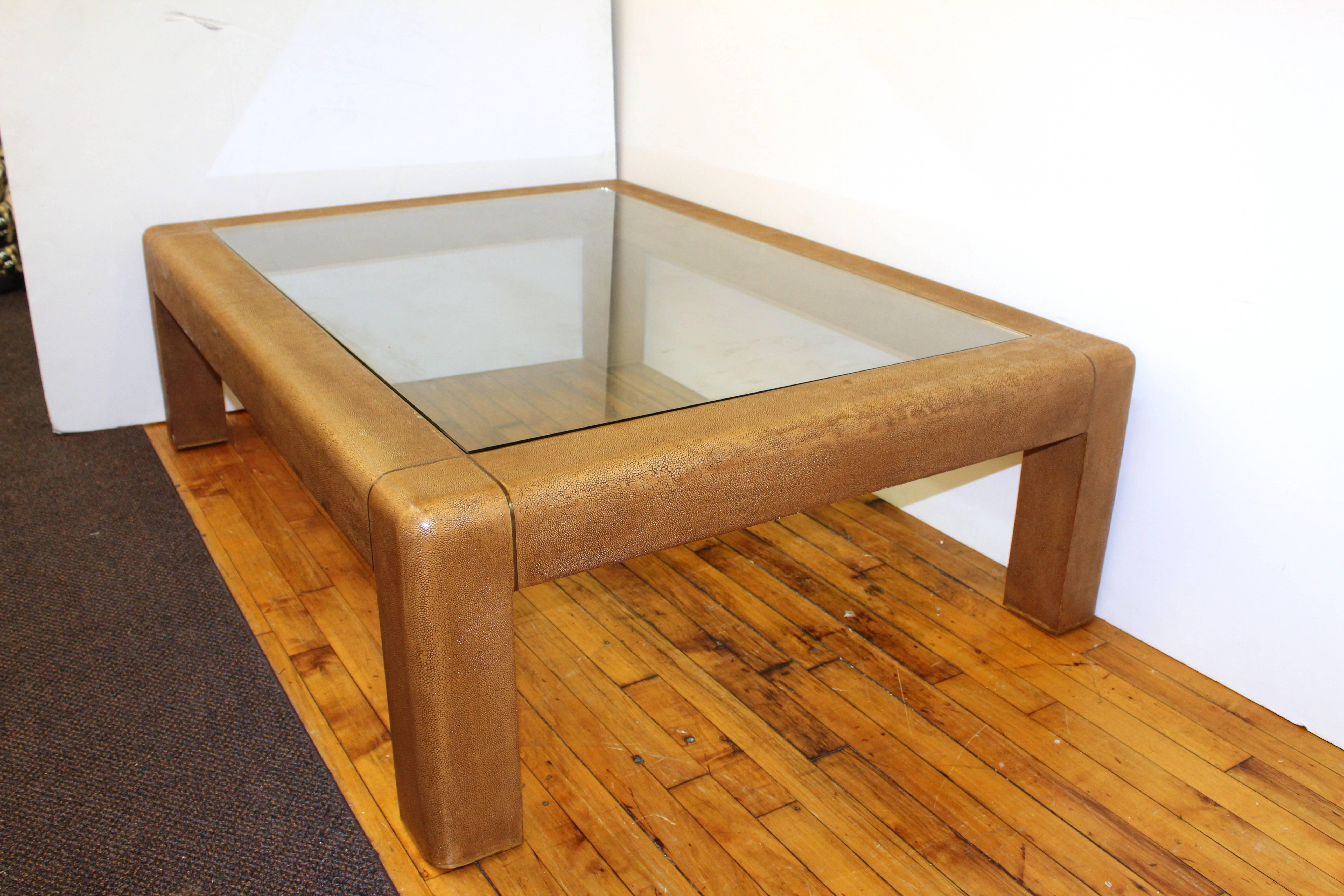 Coffee table by Karl Springer with textured brown shagreen frame and inset glass paneled top. This low coffee table is rectangular and not completely square. In good vintage condition consistent with age and use.